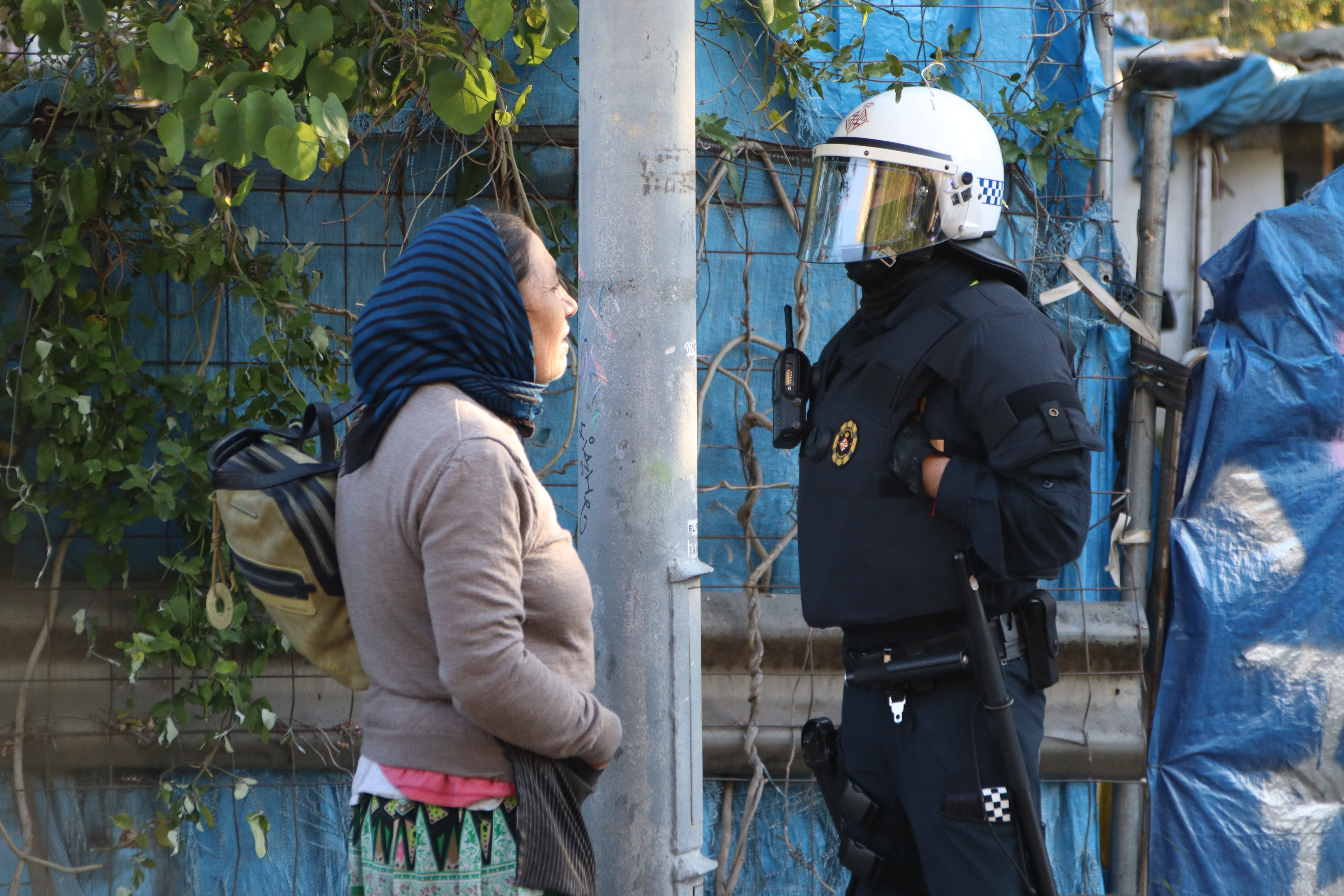 Un agent de la Guàrdia Urbana conversant amb una veïna de l'assentament de Vallcarca.