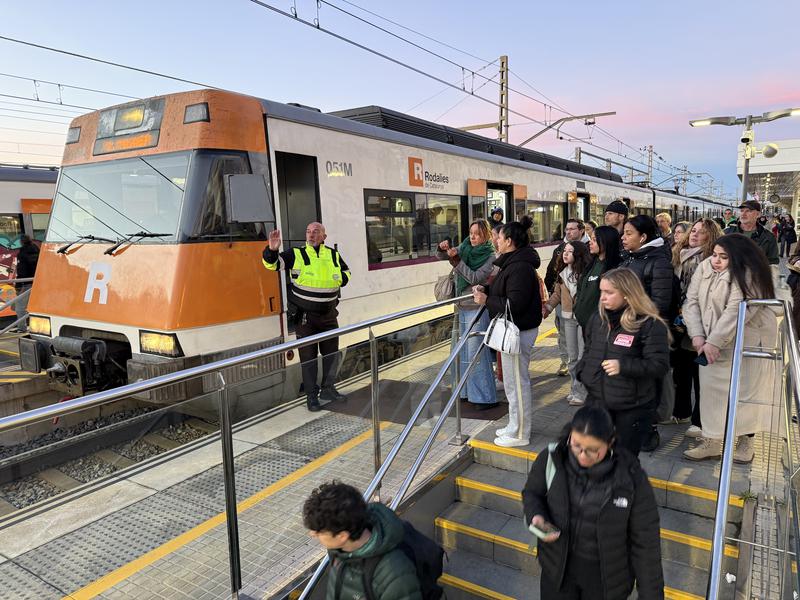 Security staff inform passengers on the platform at Arenys de Mar station