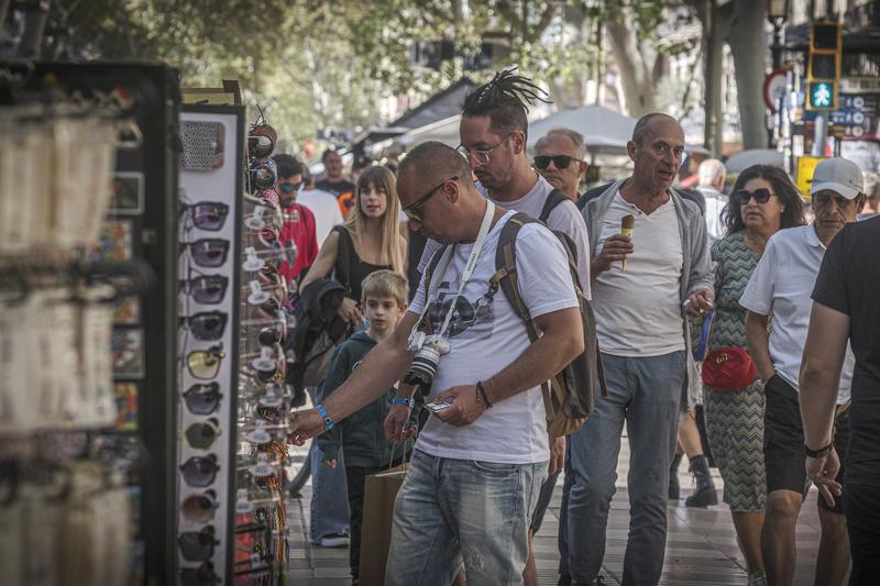 A group of tourists checking a souvenirs store in Barcelona's La Rambla boulevard