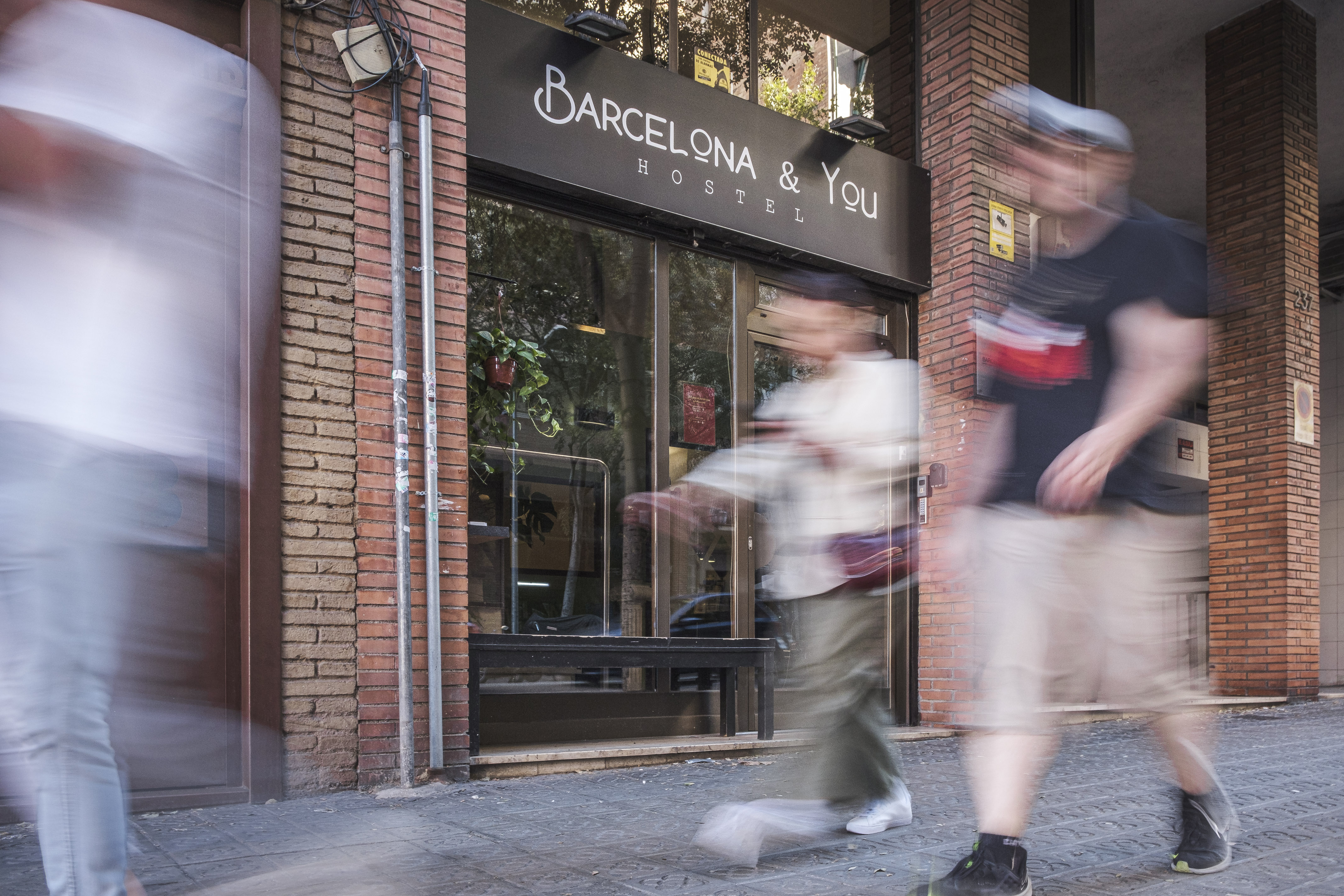 People walking in front of a hostel, one of the many tourist accommodation sites, in Barcelona