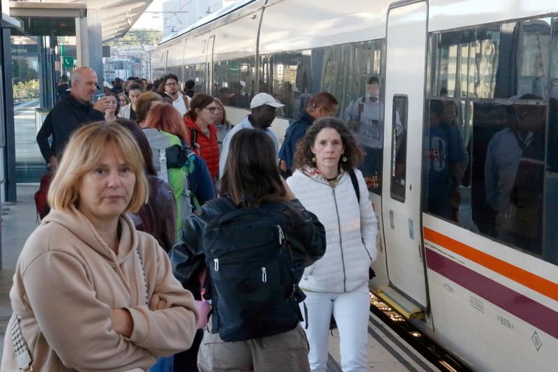 Passengers boarding a train to Barcelona at Girona station.