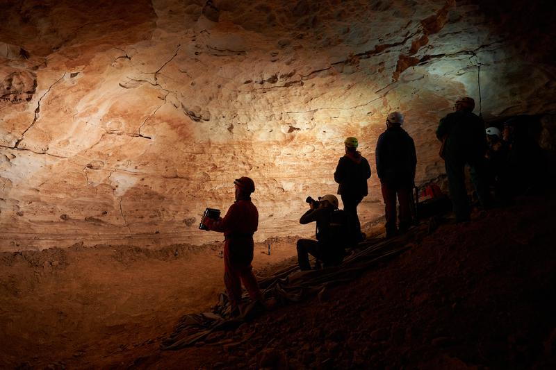 Speleologists admiring the prehistoric cave art near the town of La Febró in southern Catalonia