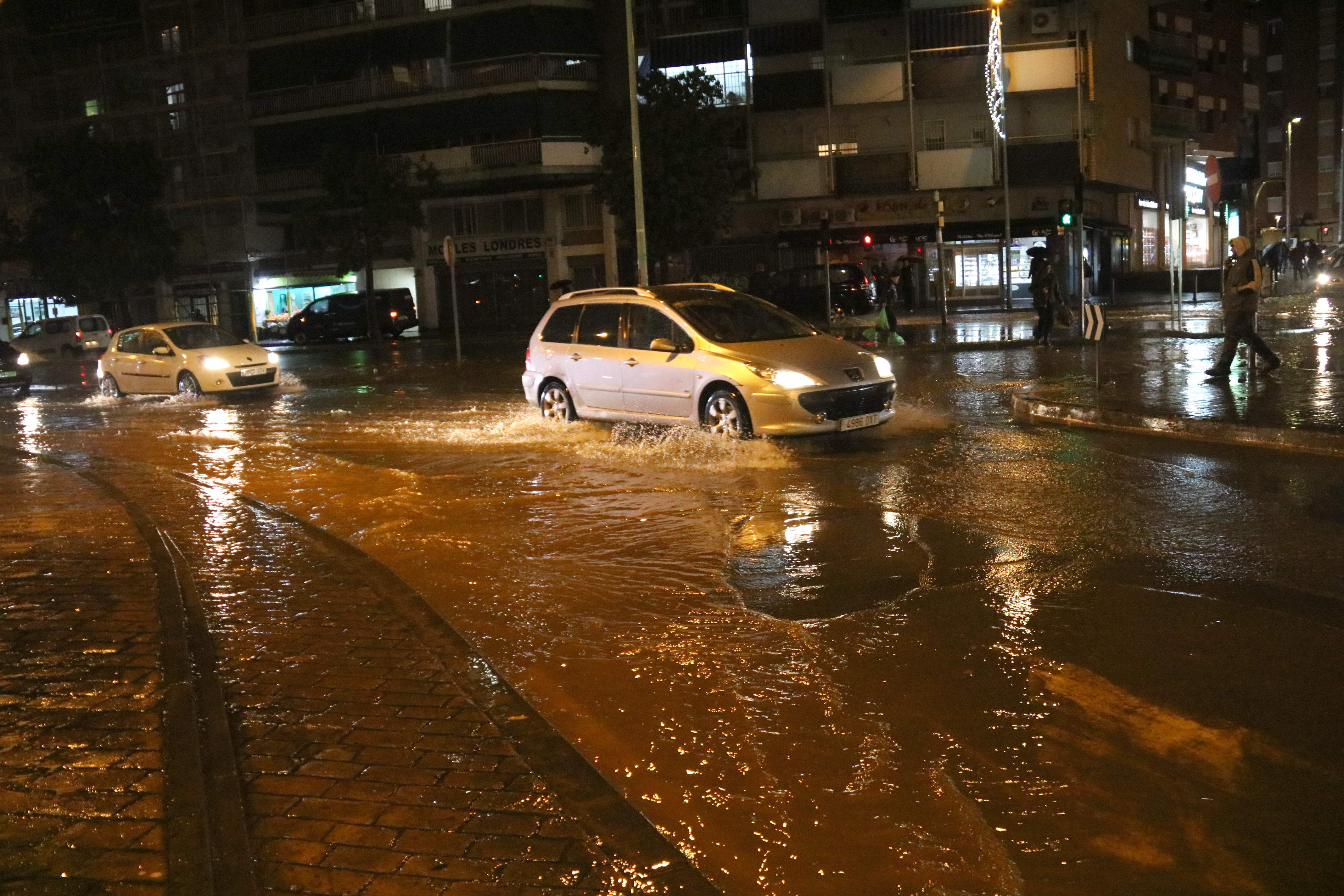 Cars navigate a flooded Carrer Alfons XIII in Badalona