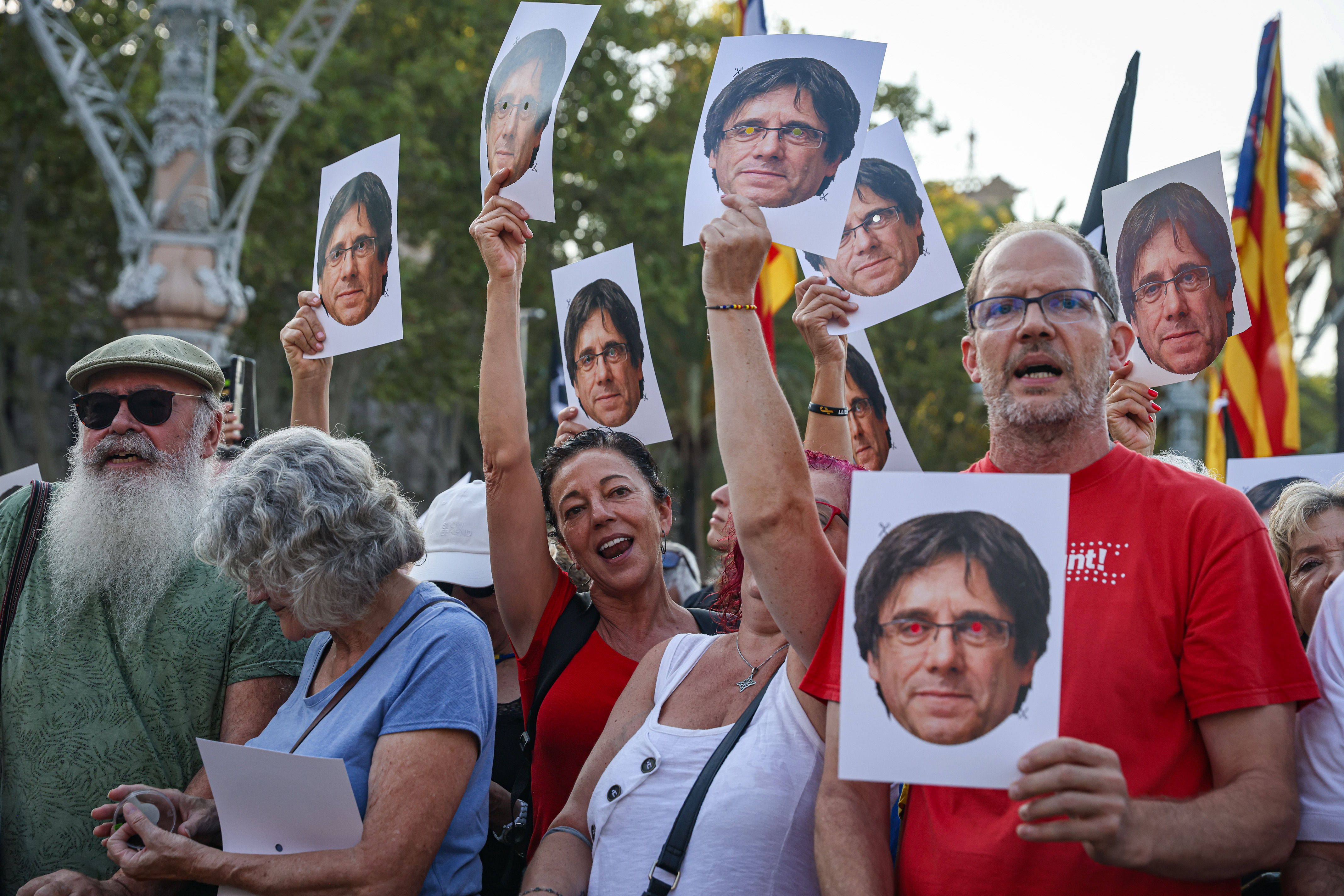 Pro-independence supporters hold up posters with Carles Puigdemont's face as the former president returns to Catalonia for the first time in seven years