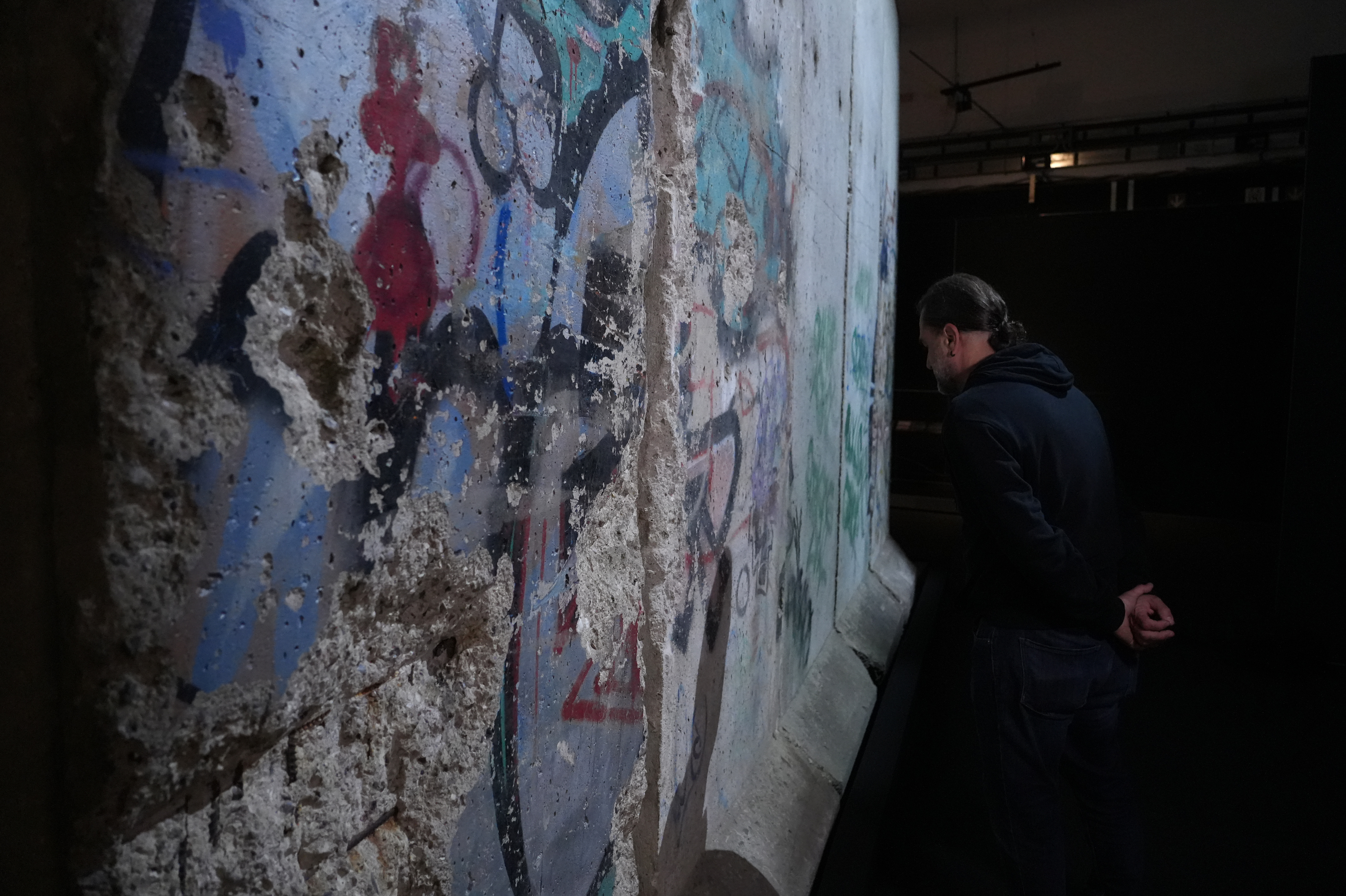 A visitor observes sections of the Berlin Wall