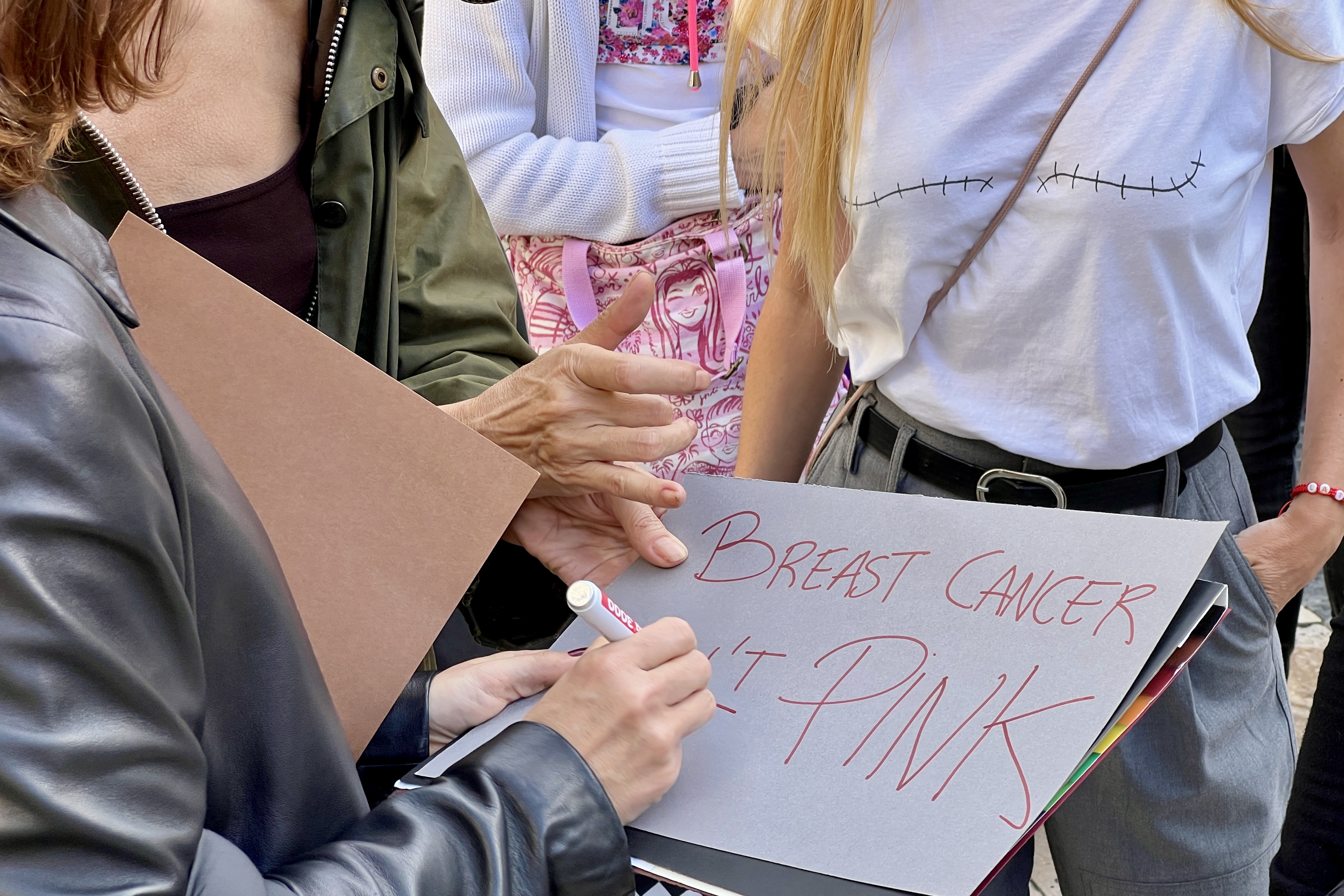 A poster reads 'Breast Cancer is not Pink' during a demonstration on International Day Against Breast Cancer on October 19, 2024