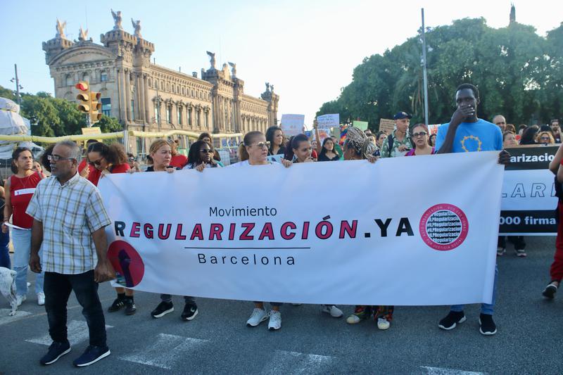 Banner calling for the regularization of migrants at an anti-colonialism protest in Barcelona