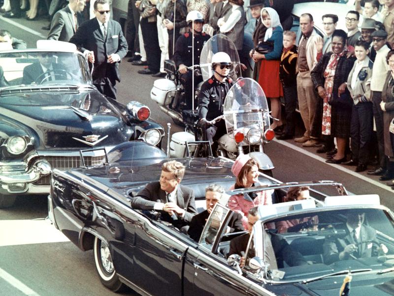 President Kennedy in the limousine in Dallas, Texas, on Main Street, minutes before the assassination. Also in the presidential limousine are Jackie Kennedy, Texas Governor John Connally, and his wife, Nellie.