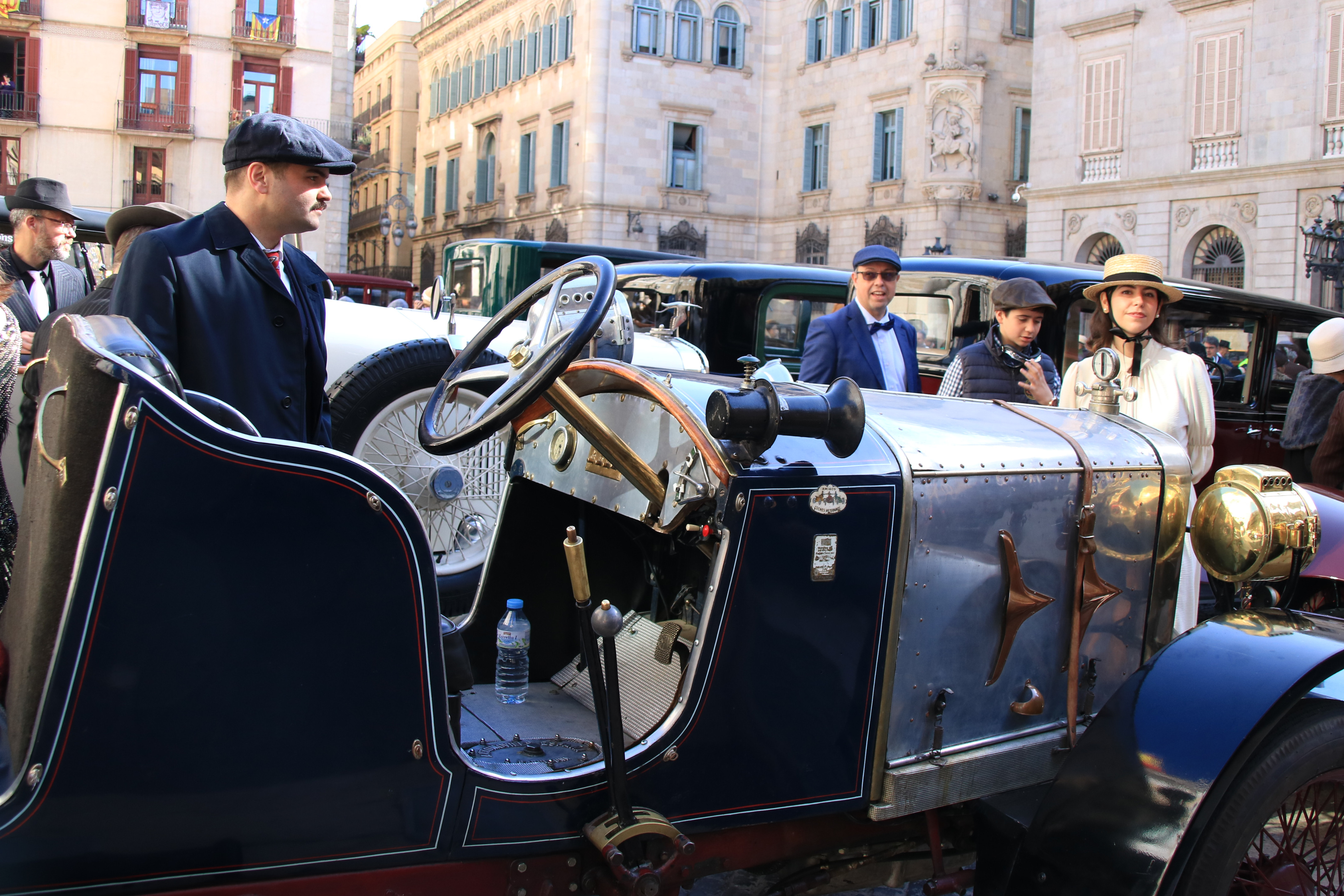 Participants del 65è Ral·li Internacional Barcelona-Sitges  vestits d'època al costat del seu vehicle