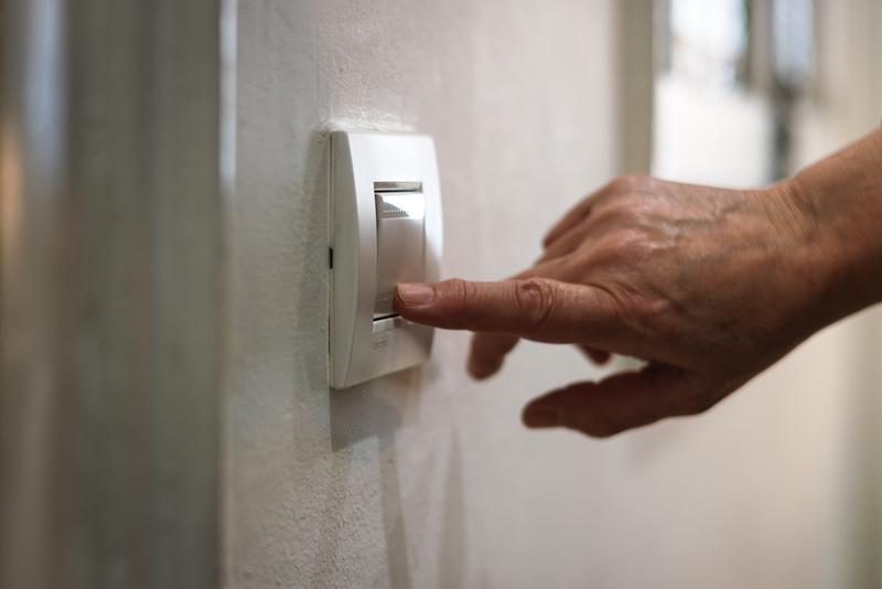 A person turns on the light at home.