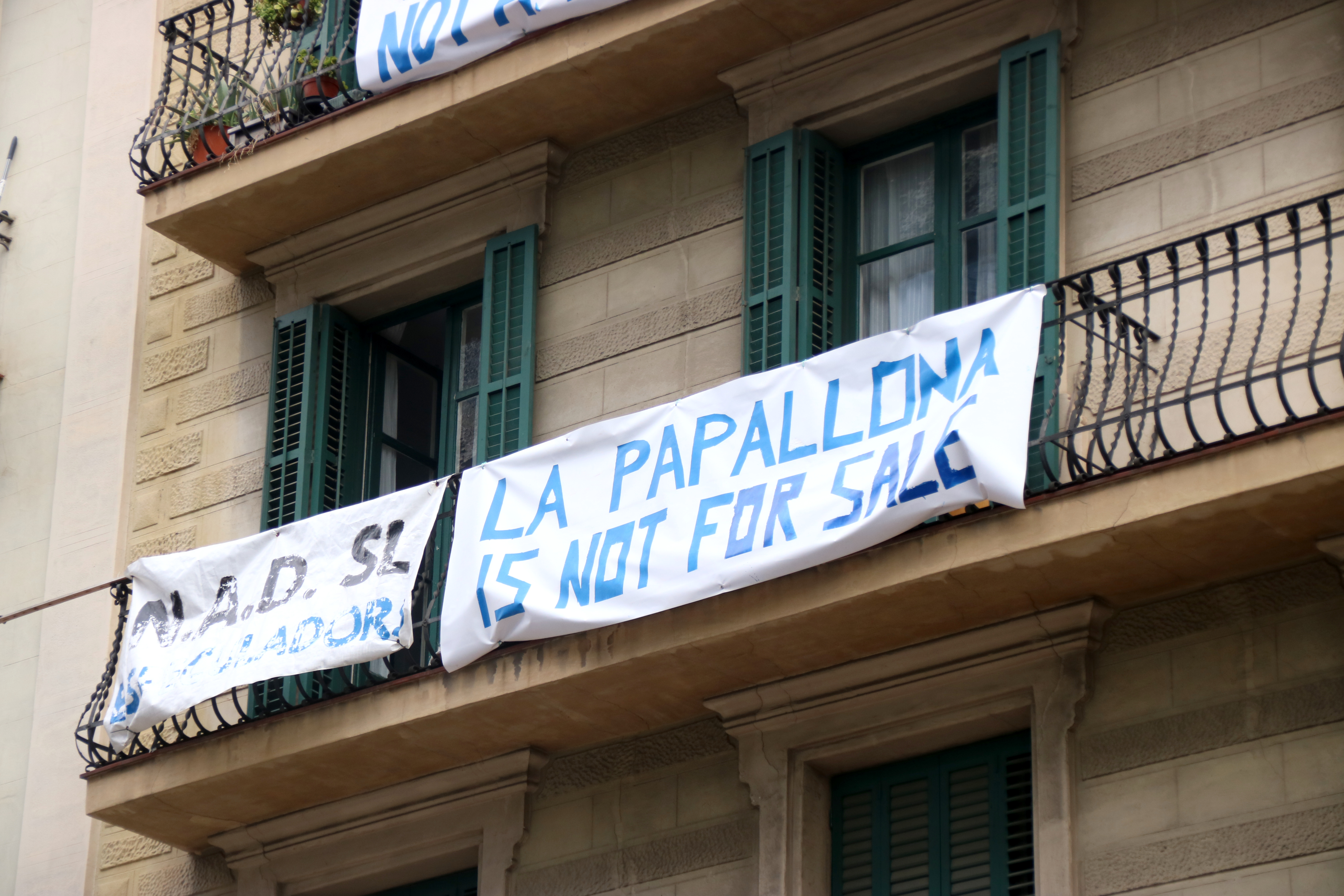 The banners hanging from the balconies of the Modernista building in Esquerra de l'Eixample