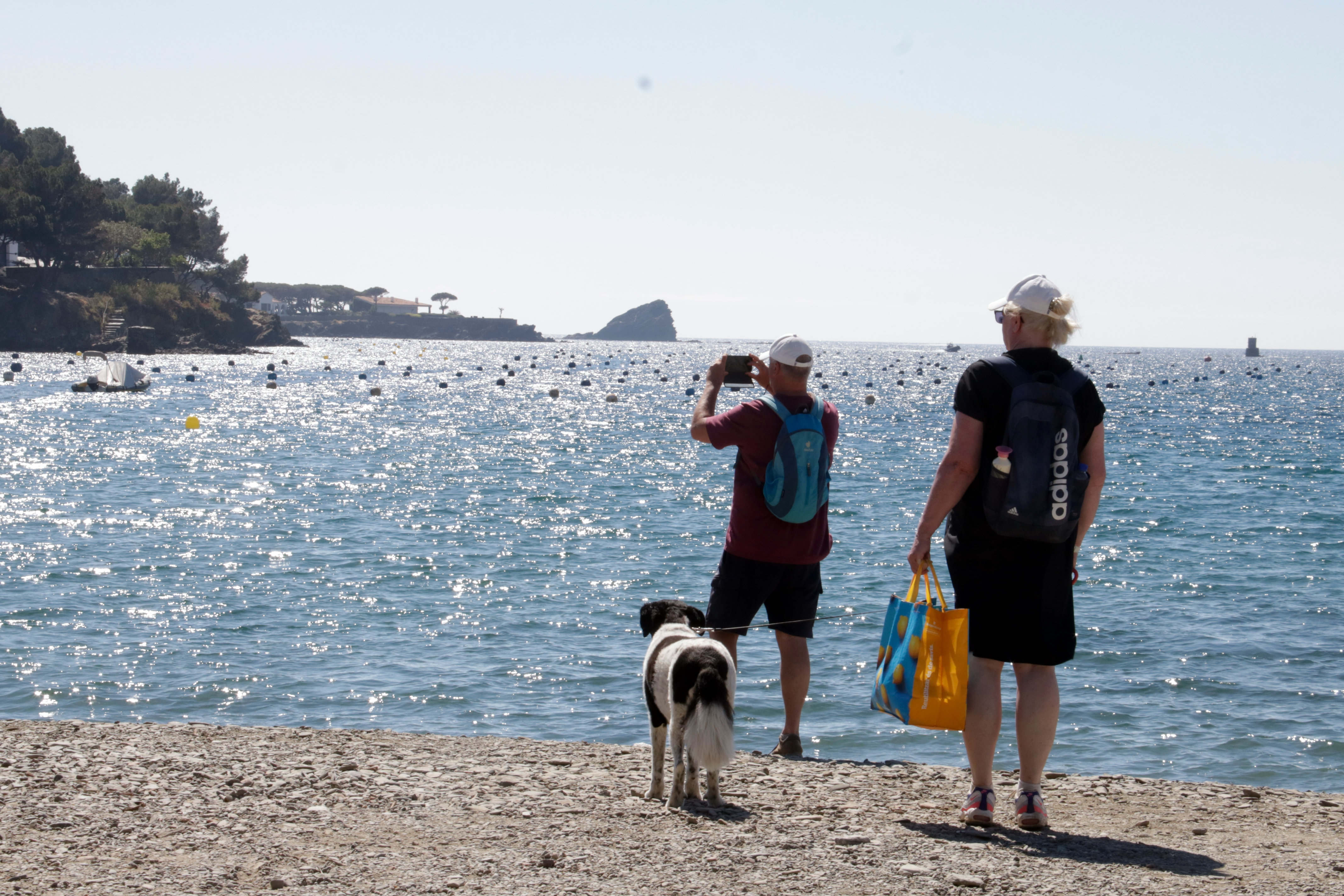 A couple and a dog on the beach in Cadaqués