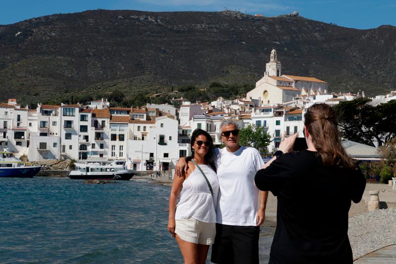 A couple of tourists take a picture with Cadaqués' famous picturesque white façades as the background