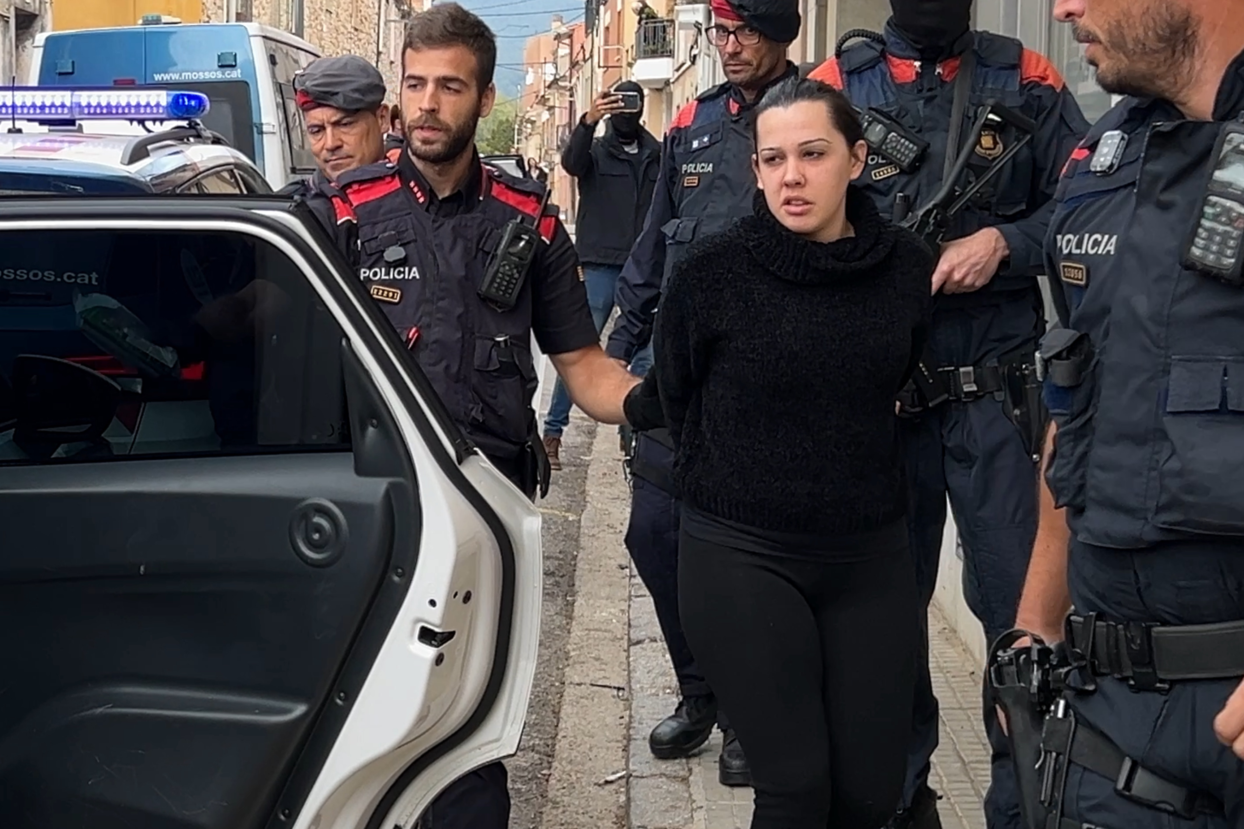 Mossos police escort a woman arrested in Sentmenat over Combat 18 links