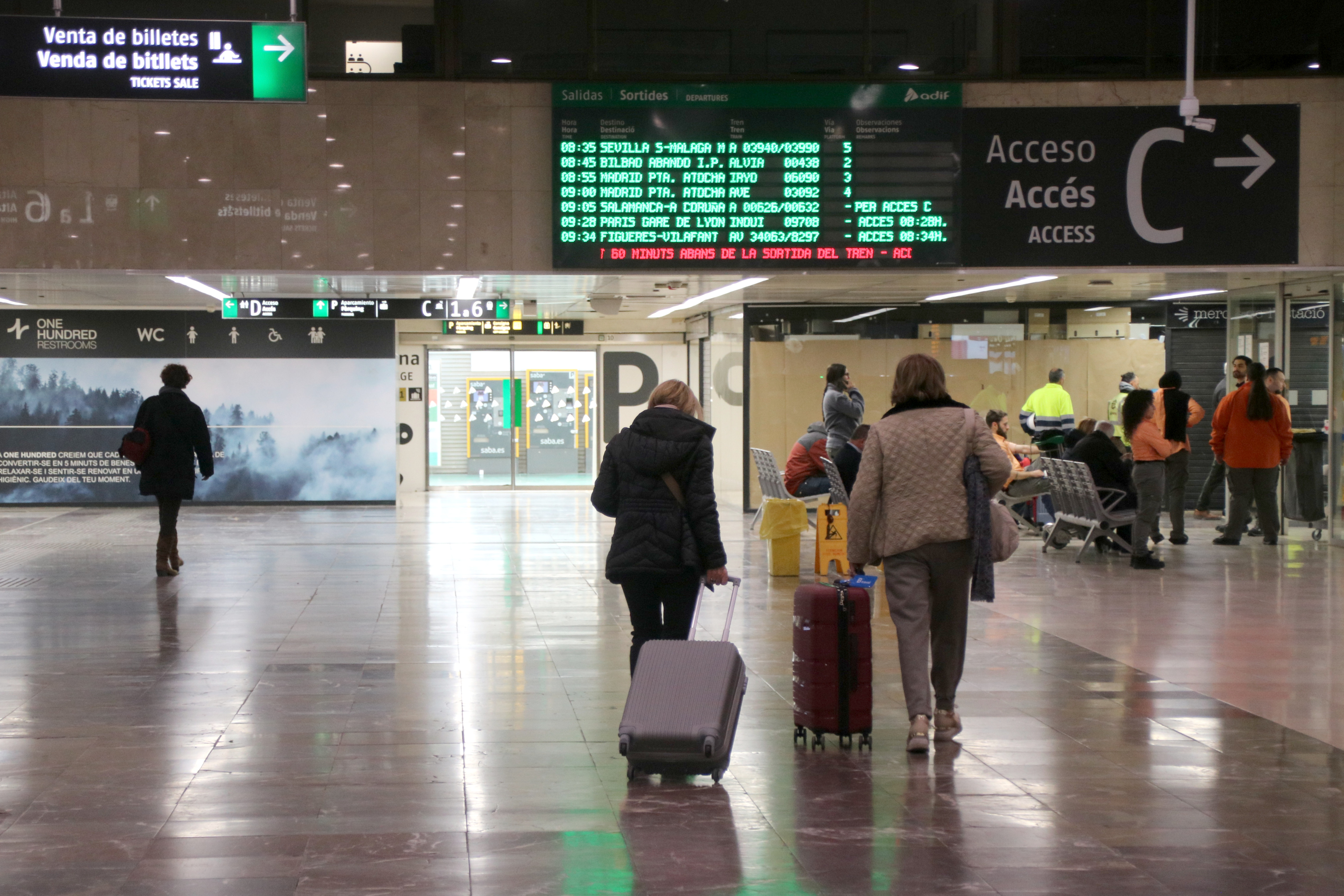 Several train passengers at Barcelona Sants train station carrying their luggage on March 17, 2025