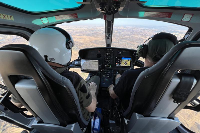 Forest rangers mark out the perimeter of a wildfire from a helicopter