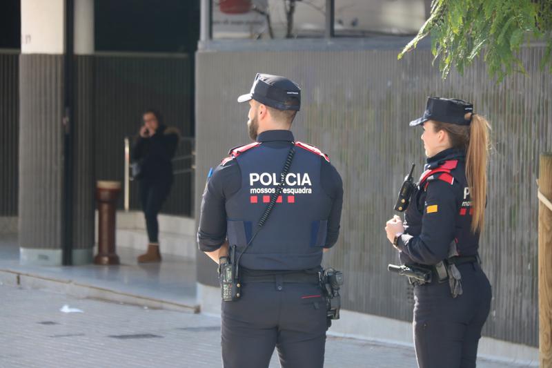 Two police officers outside the headquarters building of the Catalan Football Federation