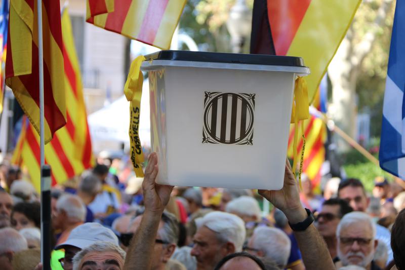 A protester holds up a 2017 referendum ballot box on the sixth anniversary of the vote