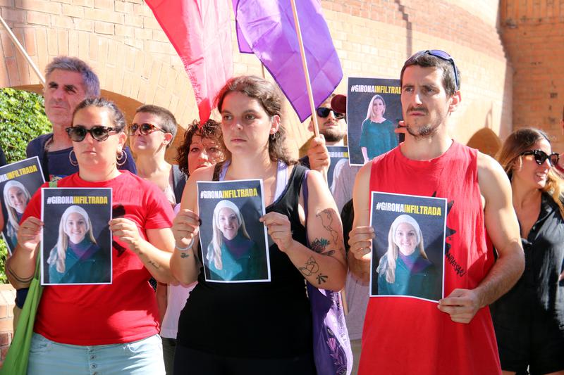 Activists hold posters of the officer from Spain's National Police they accuse of infiltrating grassroots groups in Girona and Salt