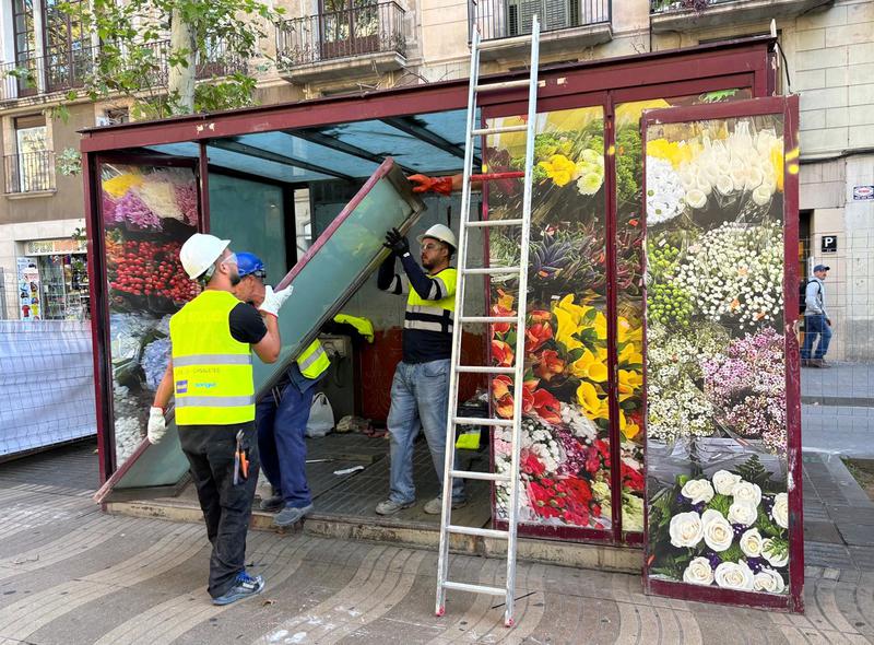 Several workers disassemble one of the 'old bird shops' or 'ocellaires' stalls in Barcelona's famous La Rambla boulevard on October 22, 2024