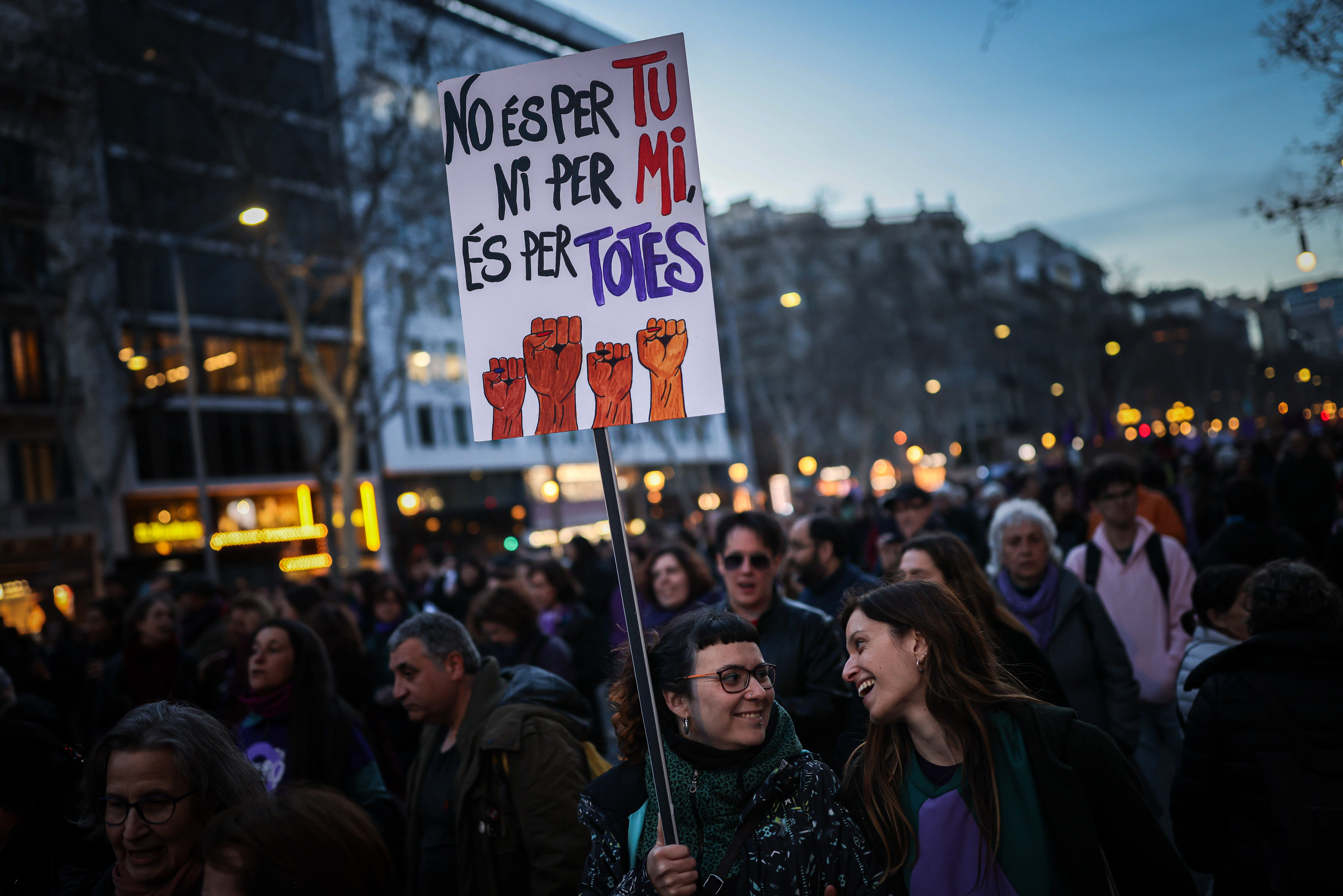 Dues dones somriuen durant la manifestació del 8-M a Barcelona