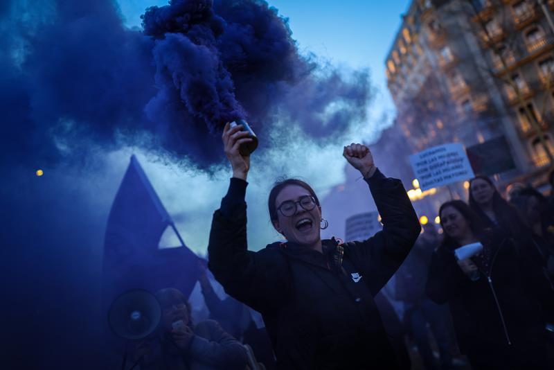 A women holds a smoke flare during the International Women's Day march in Barcelona