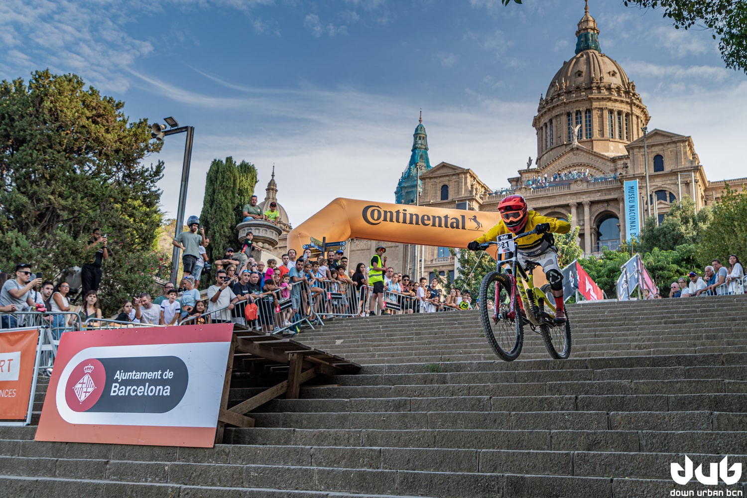 A cyclist competing at the Down Urban Barcelona 2023 in the Montjuïc mountain in front of the Catalan National Art Museum (MNAC)