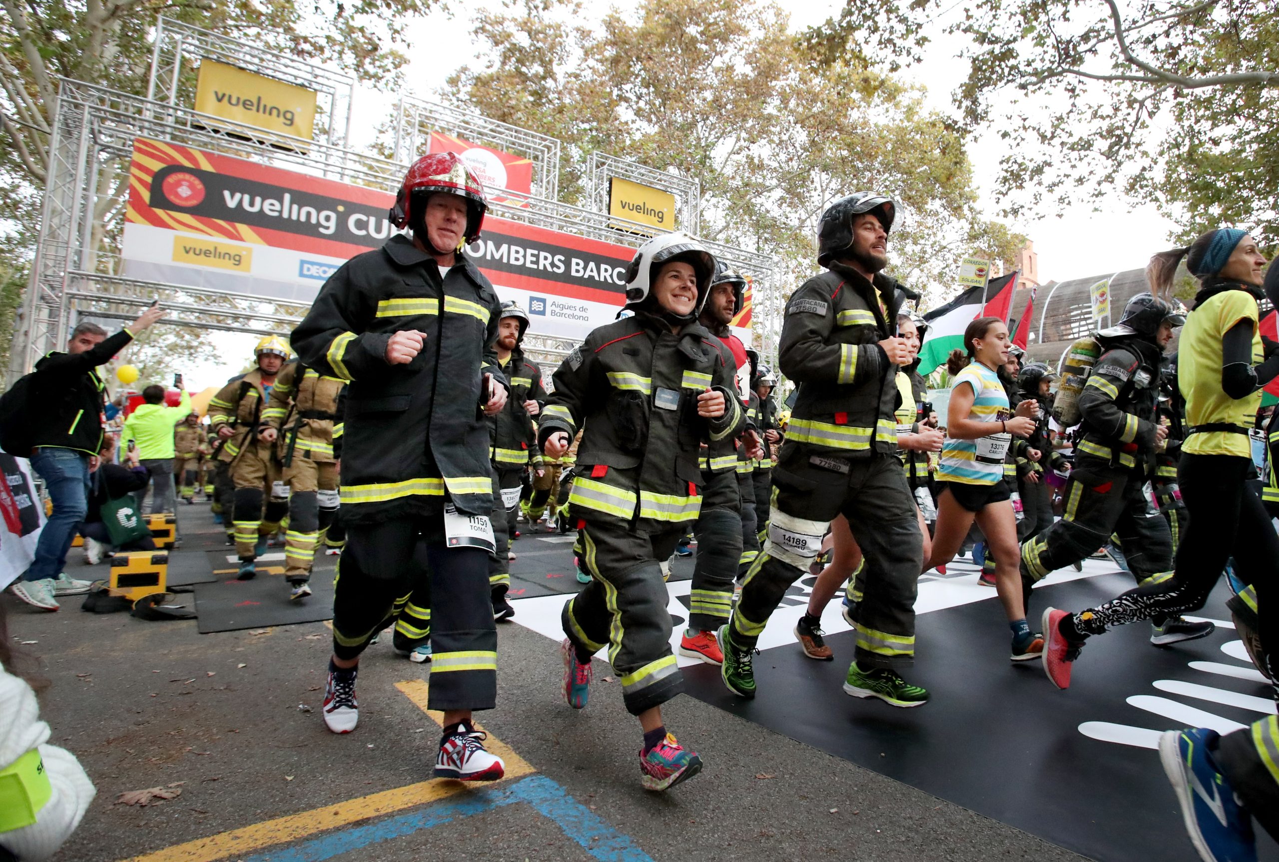 The firefighters' race takes place in Barcelona, with firefighters dressed up competing against dozens of runners