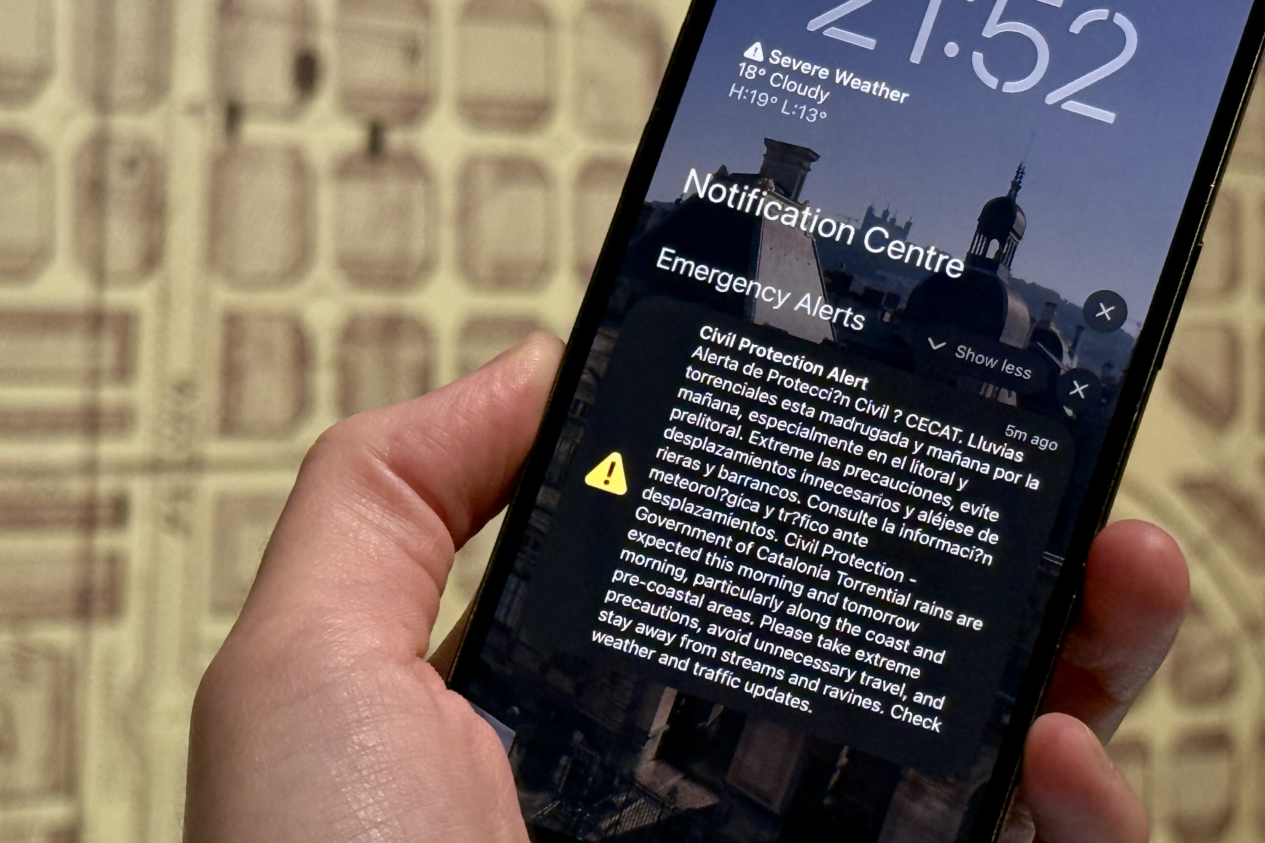 A phone shows an emergency alert message sent by the Catalan civil protection on November 5, 2025