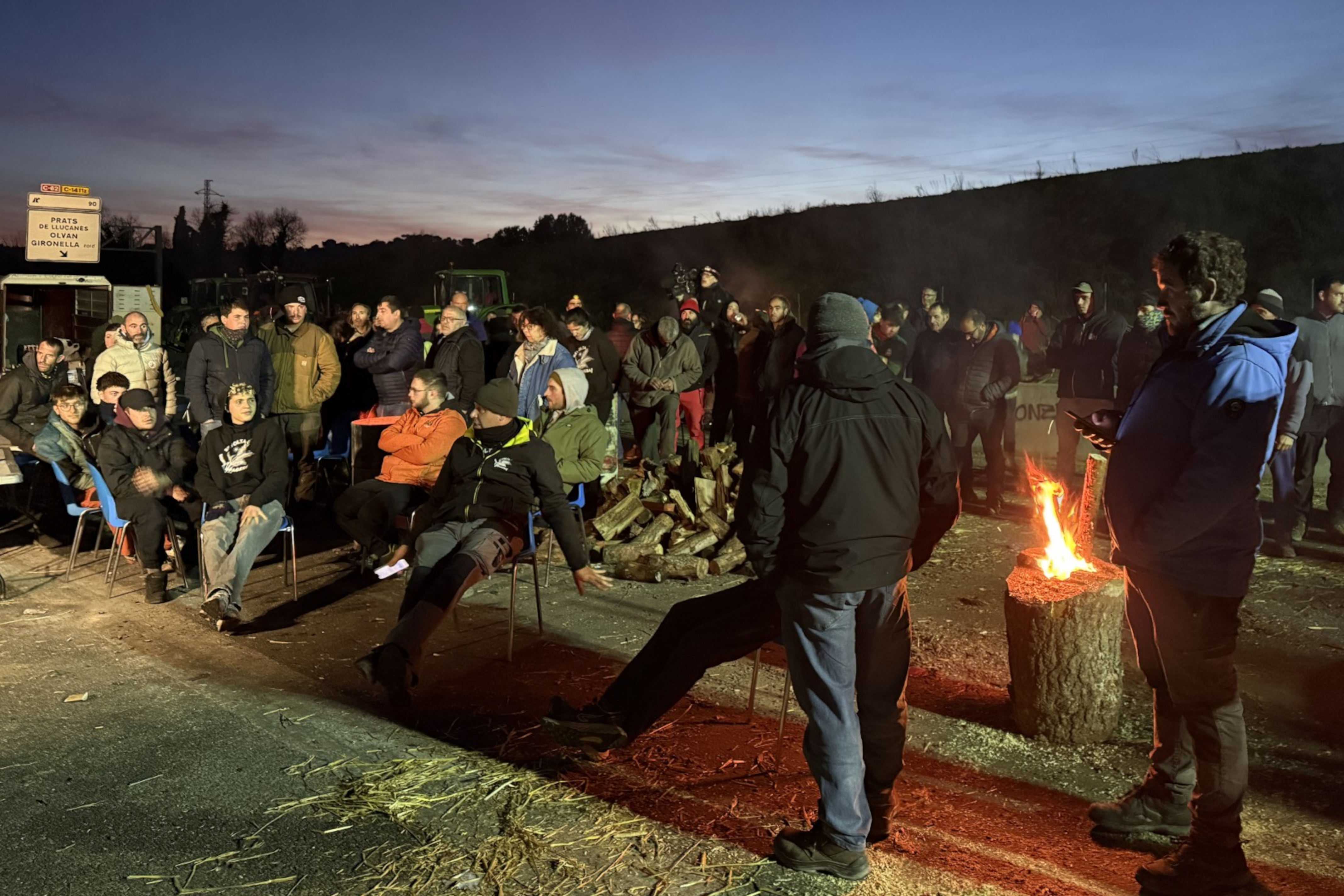 Farmers listen as Catalan president Salvador Illa addresses protesters