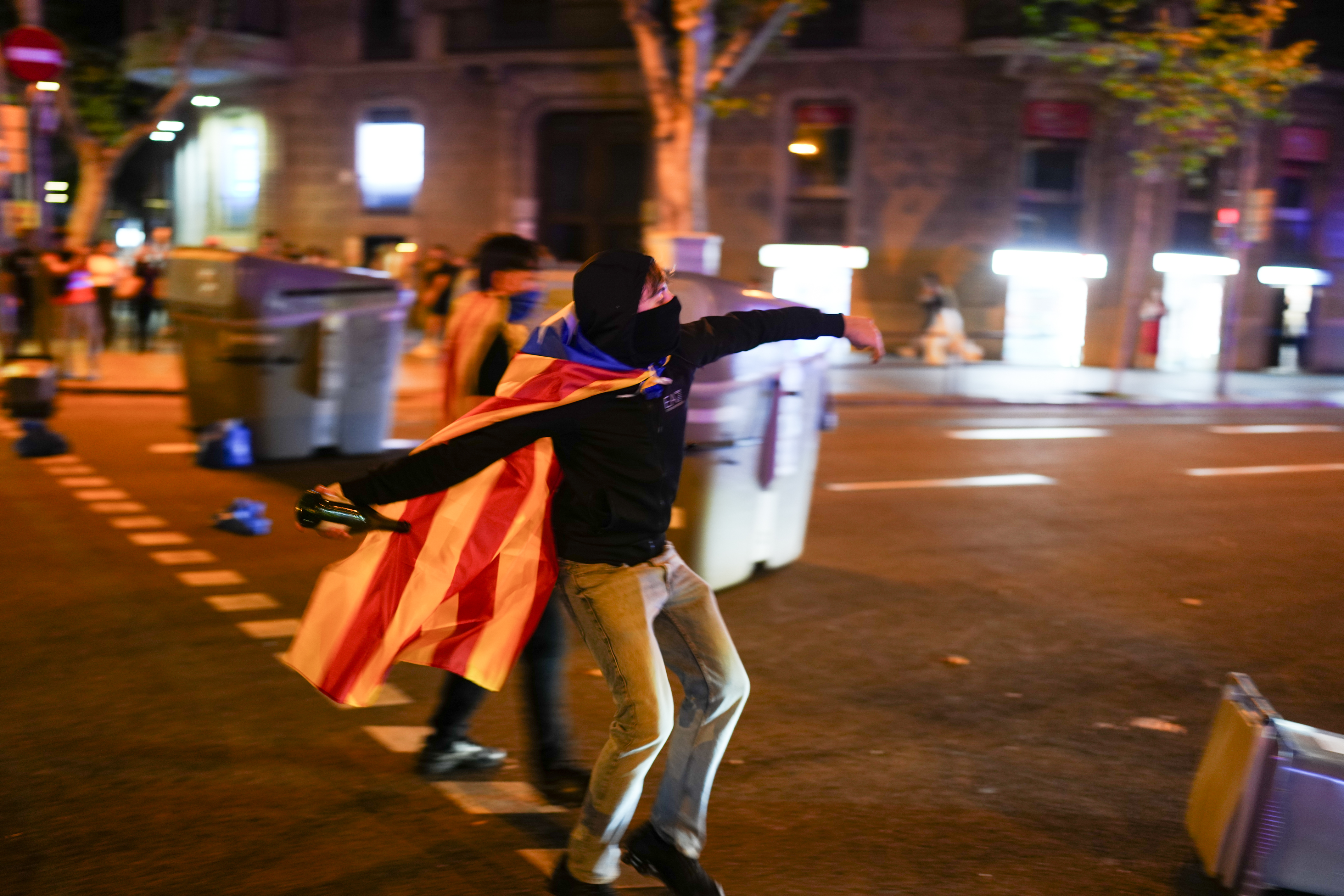 A protester throws objects after the demonstration marking the ninth anniversary of the 2017 referendum