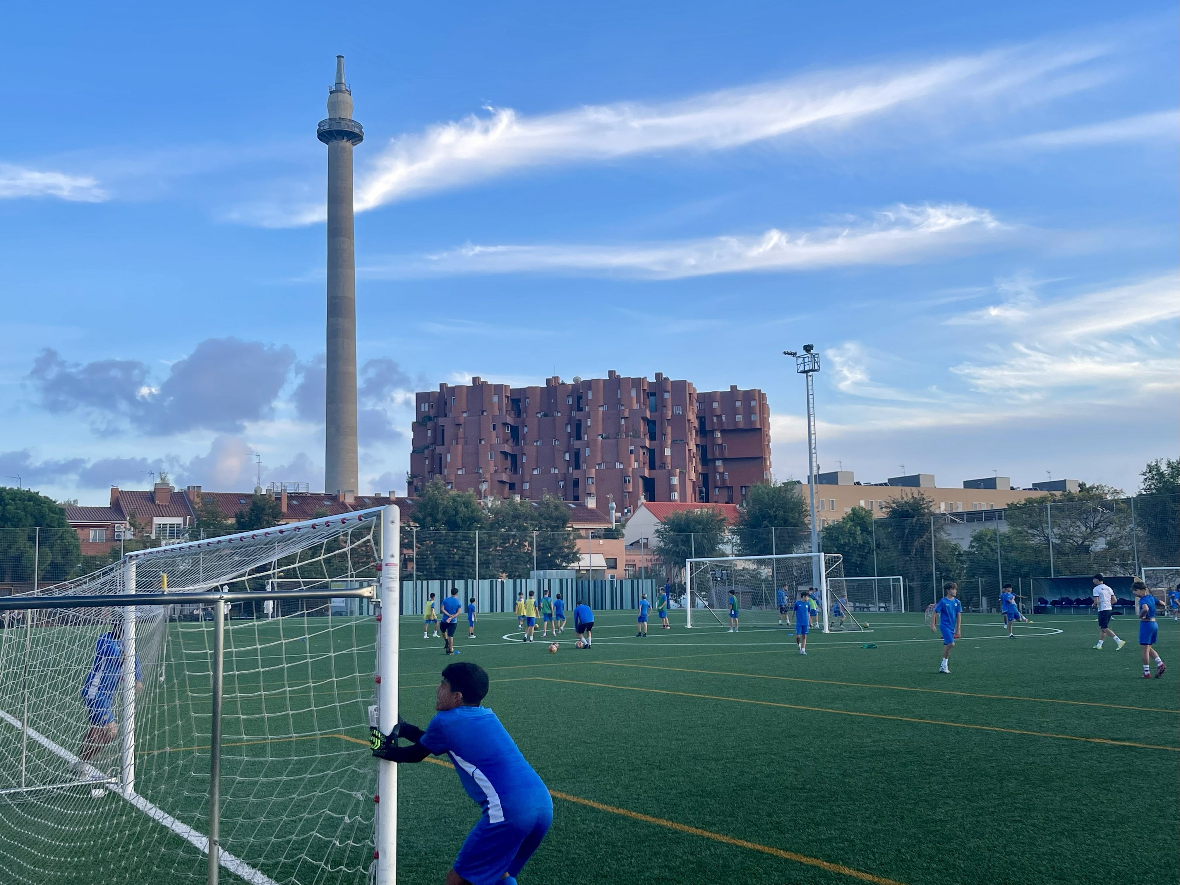 Youth teams training at Atlètic Sant Just's facilities, with Ricardo Bofill's Walden 7 apartment building and studio tower in the background