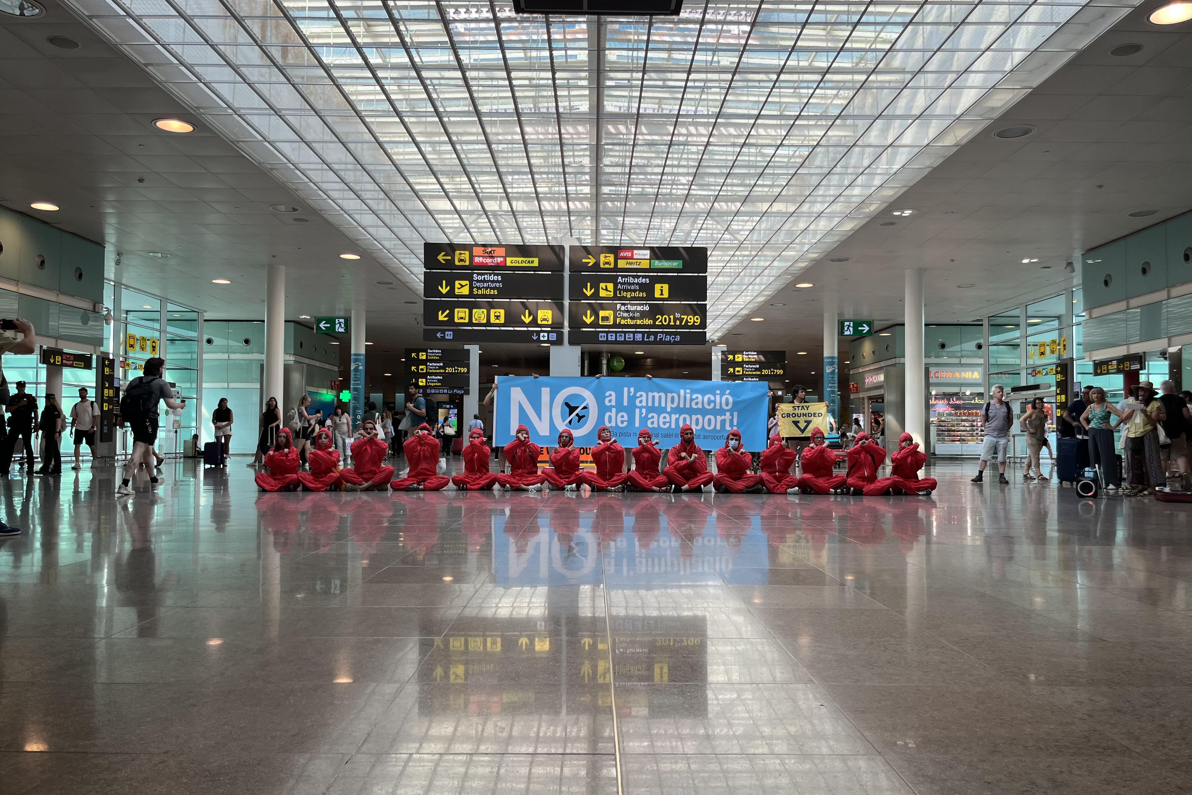 Environmental activists protest at Barcelona airport's Terminal 1 against the expansion dressed in red