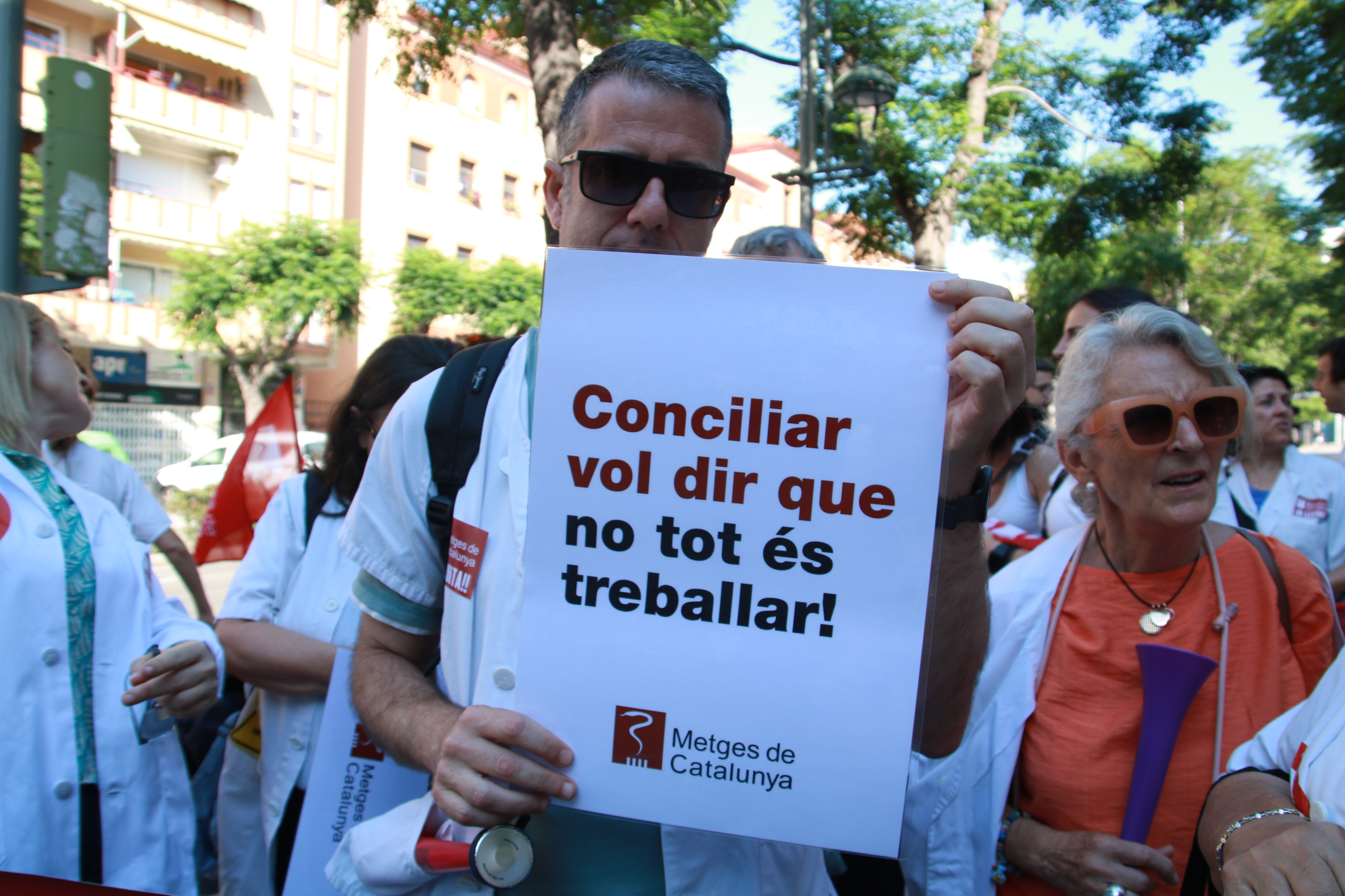 A protesting doctor in Tarragona holds a sign: 'Work-life balance means that not everything is work'