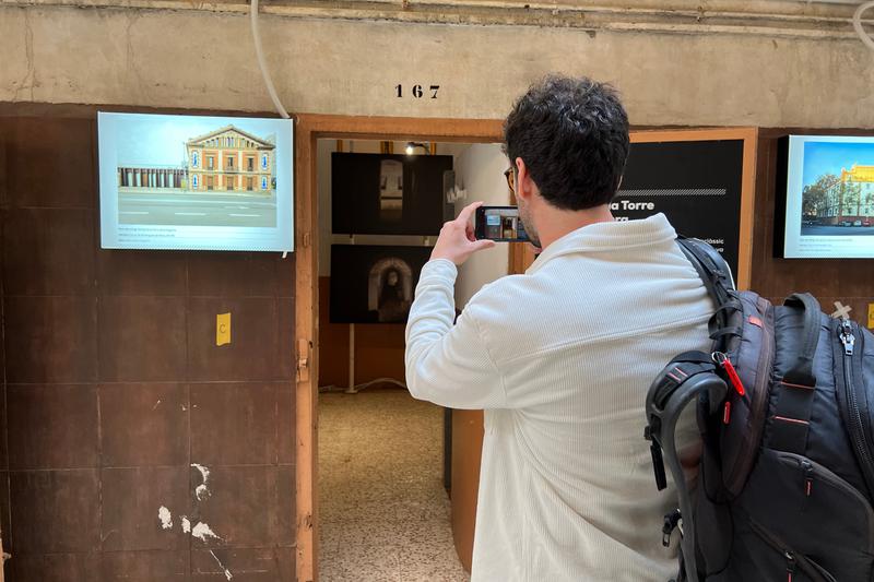 A visitor takes a picture of one of the cells during a visit to the 1,322 bomb shelters exhibition in Barcelona 'La Model' prison on March 29, 2023