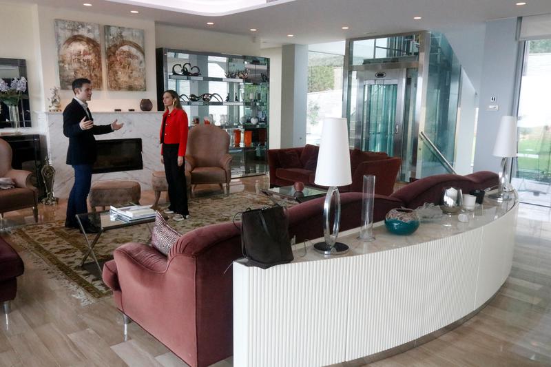 Real estate agency workers from Barnes chat in the living room of a home they are selling in the Girona area