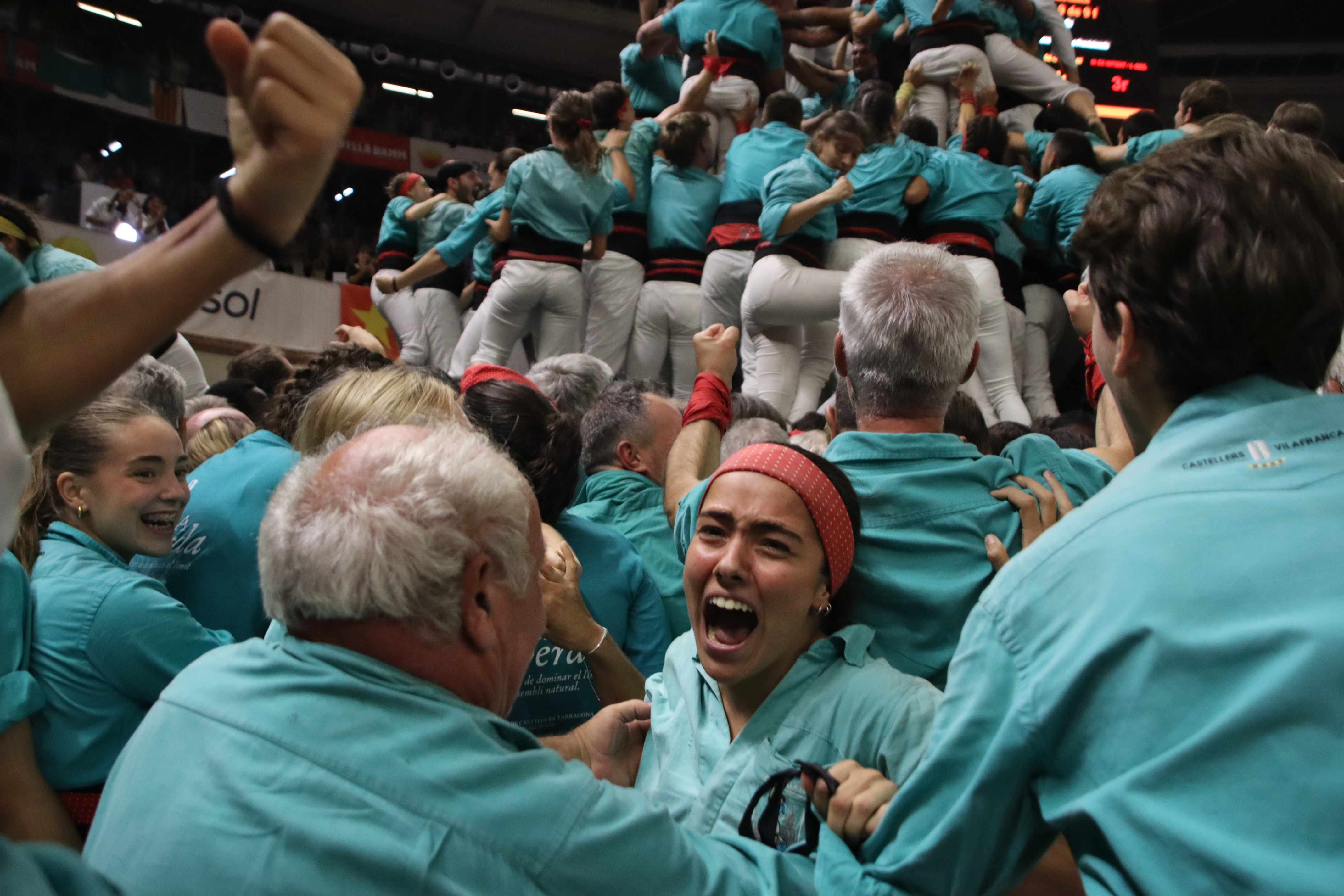 A castellera from Villafranca screams with joy after successfully completing the*9 de 9 amb folre. securing their title as champions of the 30th Tarragona Castells Competition.