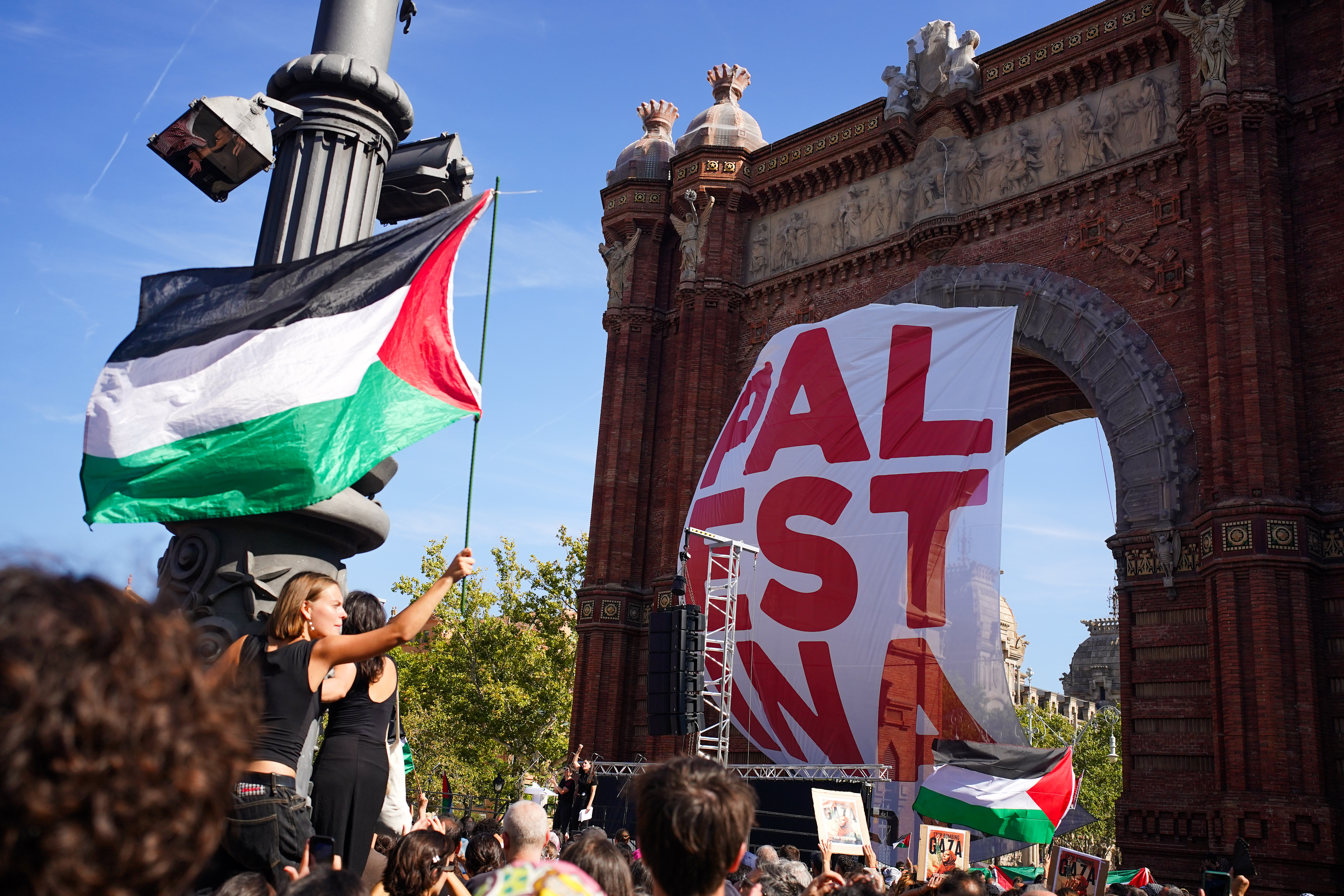 Una pancarta amb la paraula 'Palestina' penjada a l'Arc de Triomf, punt final de la manifestació
