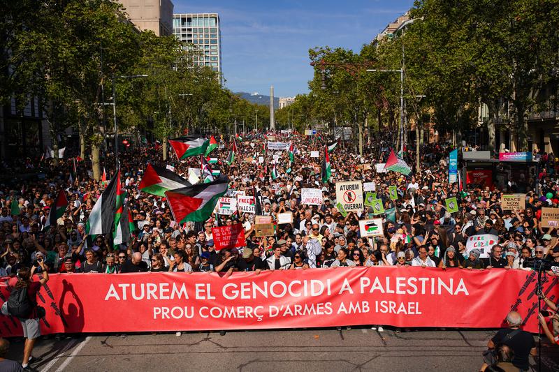 The head of the rally with a banner stating: 'Let's stop the genocide in Palestine. End arms trade with Israel' 