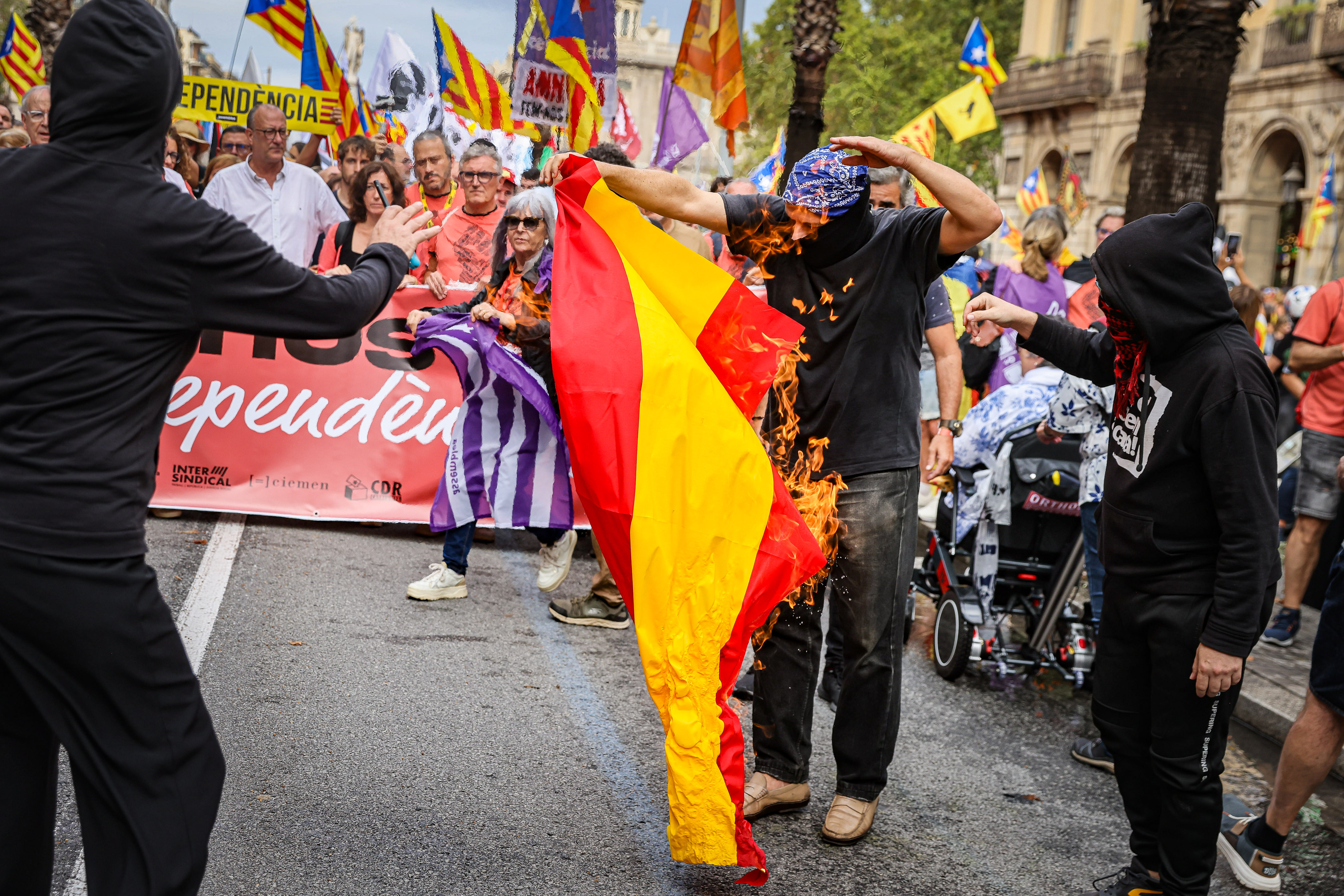 Protesters set fire to a Spanish flag