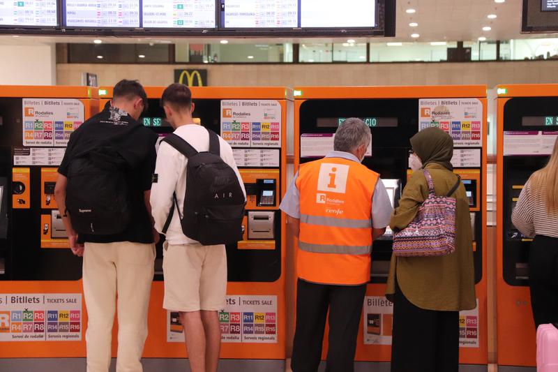 People using the Renfe ticket machines at Barcelona's Sants station