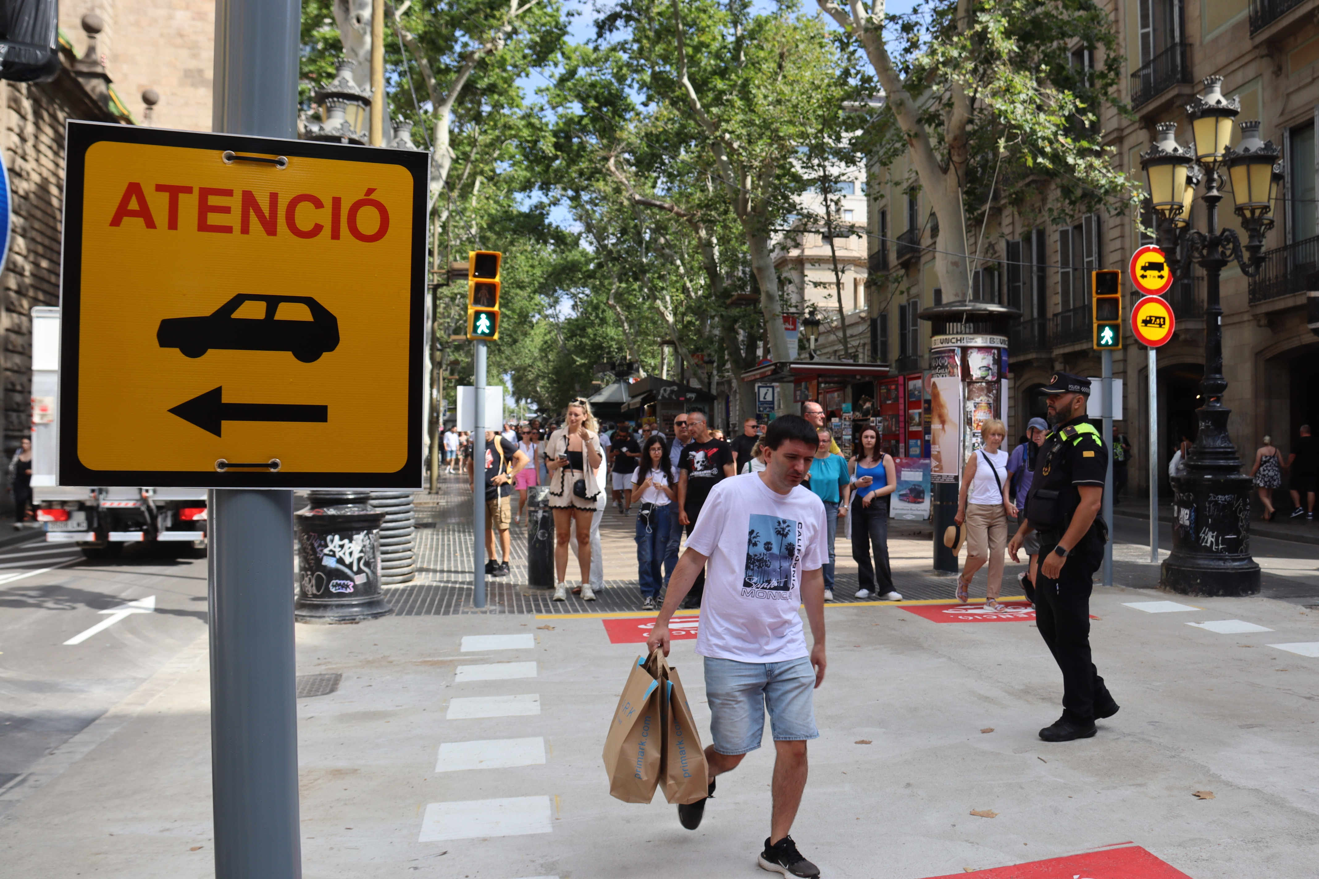 A traffic sign warning pedestrians about cars crossing the road in La Rambla boulevard