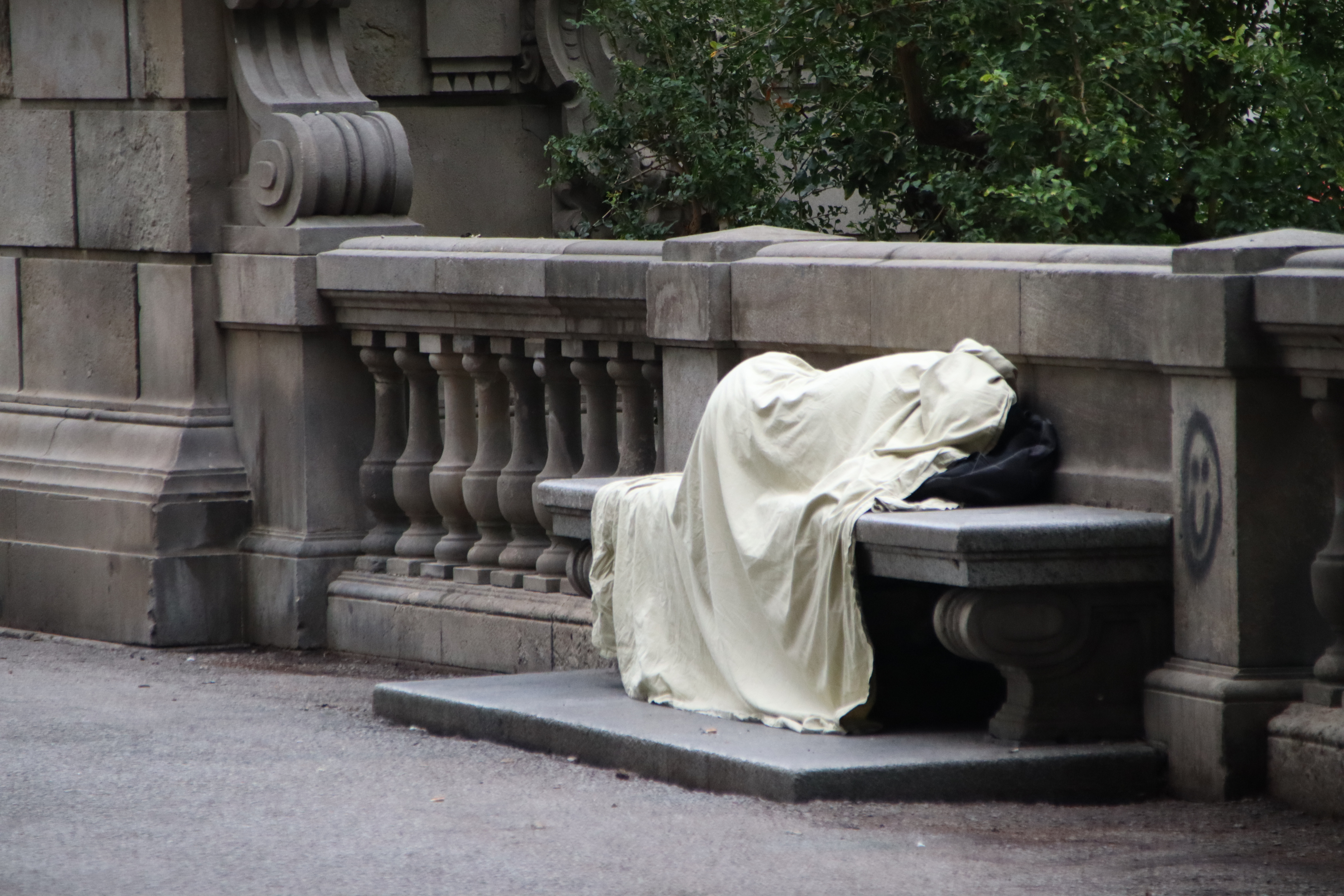 A homeless person on a bench in Plaça Catalunya.