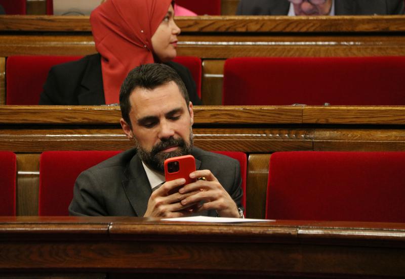 Catalan business minister Roger Torrent checking his phone