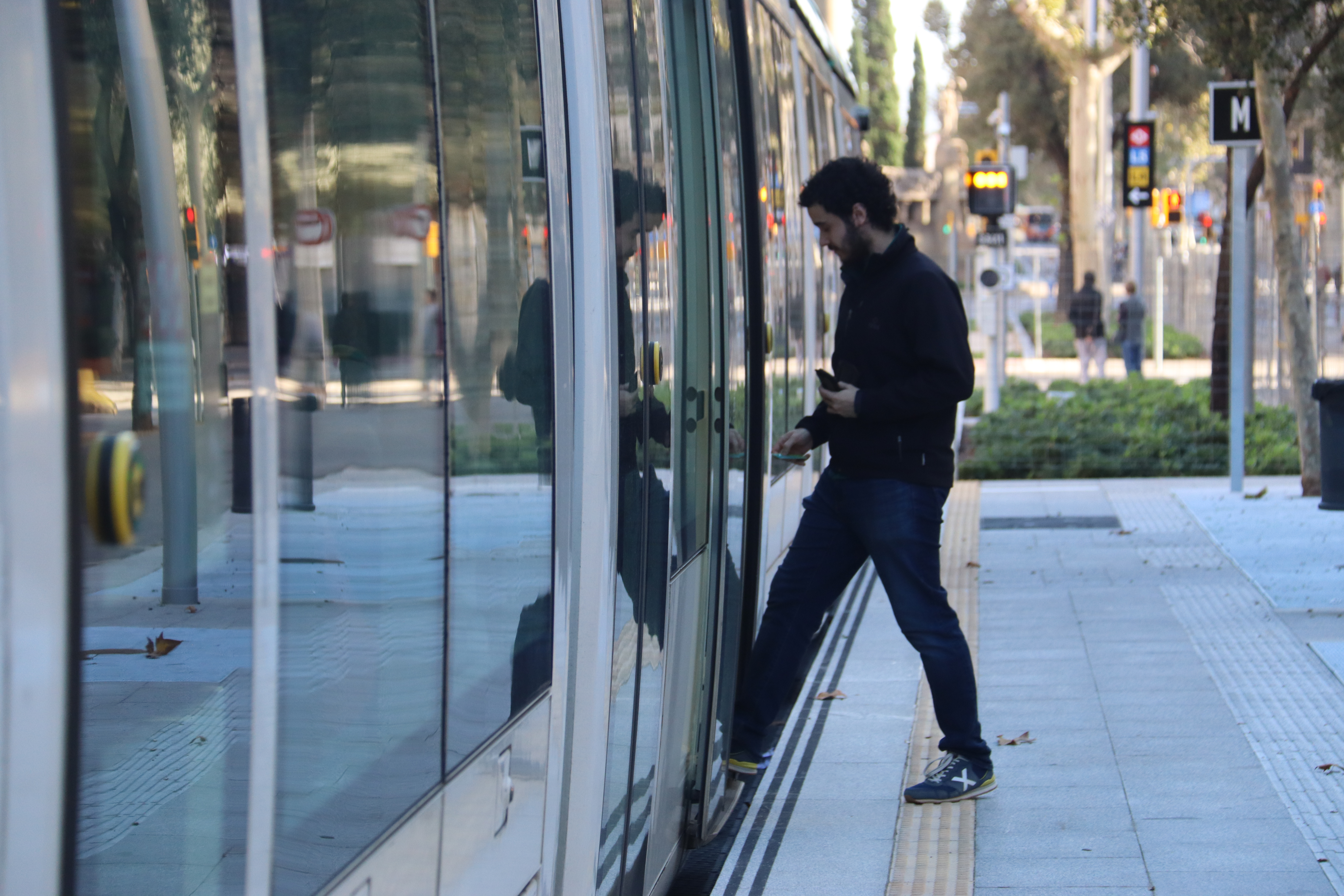 A traveler gets on the Tram at Verdaguer station