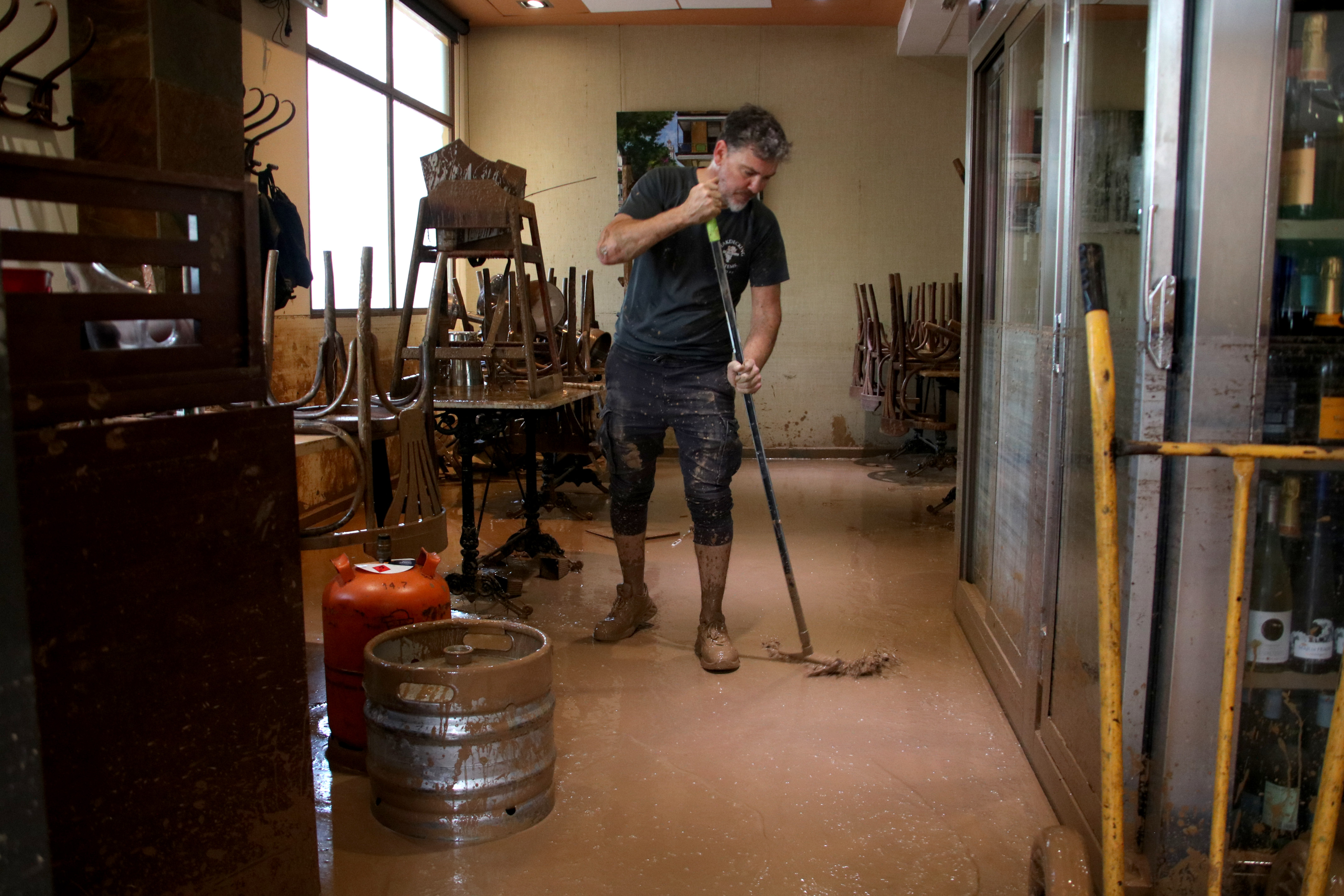 A restaurant worker in Picanya cleans up after the flood