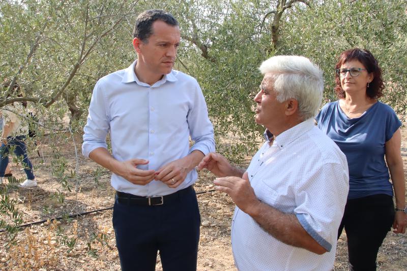 Catalonia's Agriculture Minister Òscar Ordeig speaks with President of the Cabacés Cooperative, José Antonio Robles