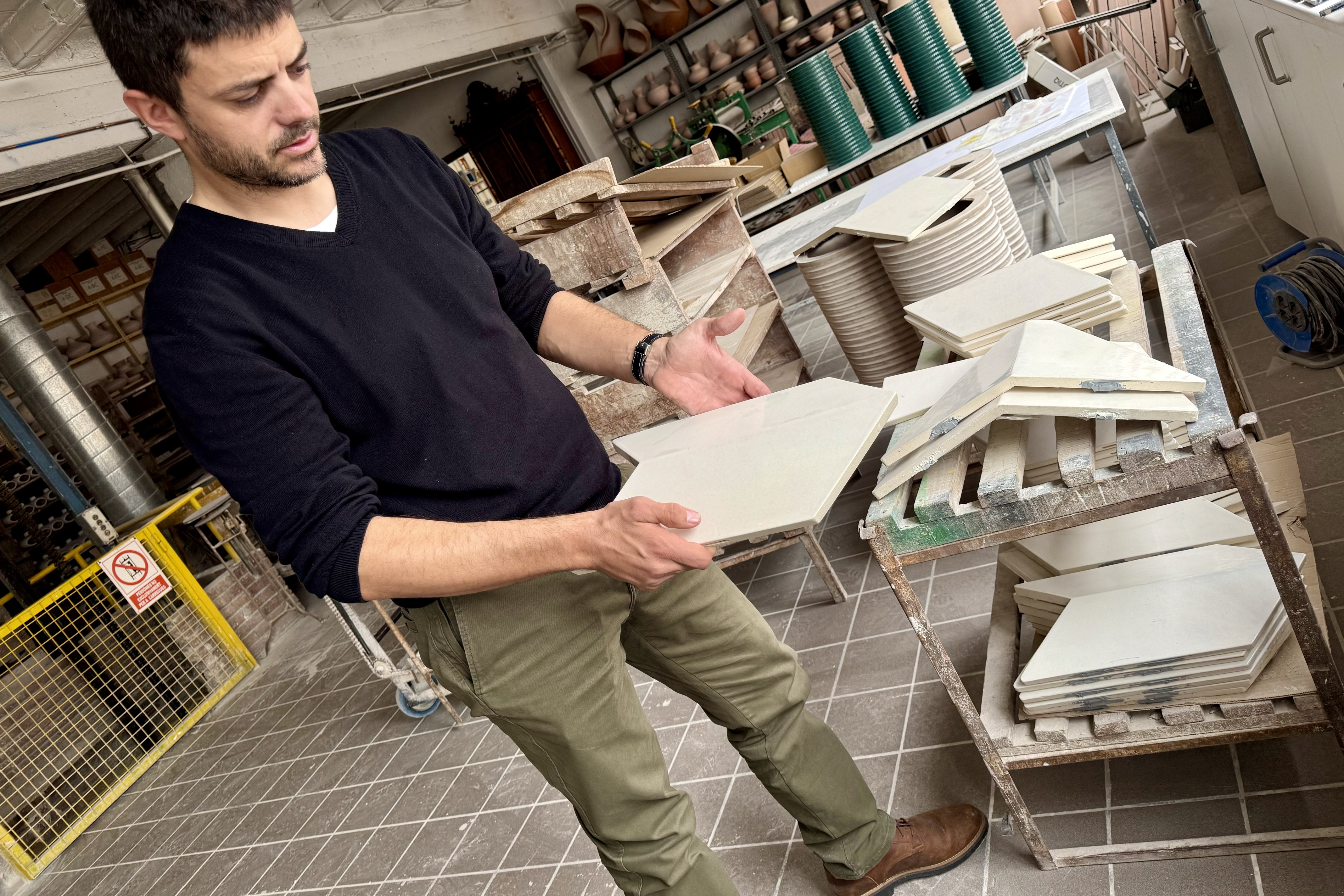 Guillem Cumella holds up a finished tile that will crown the cross of the Tower of Jesus of the Sagrada Família