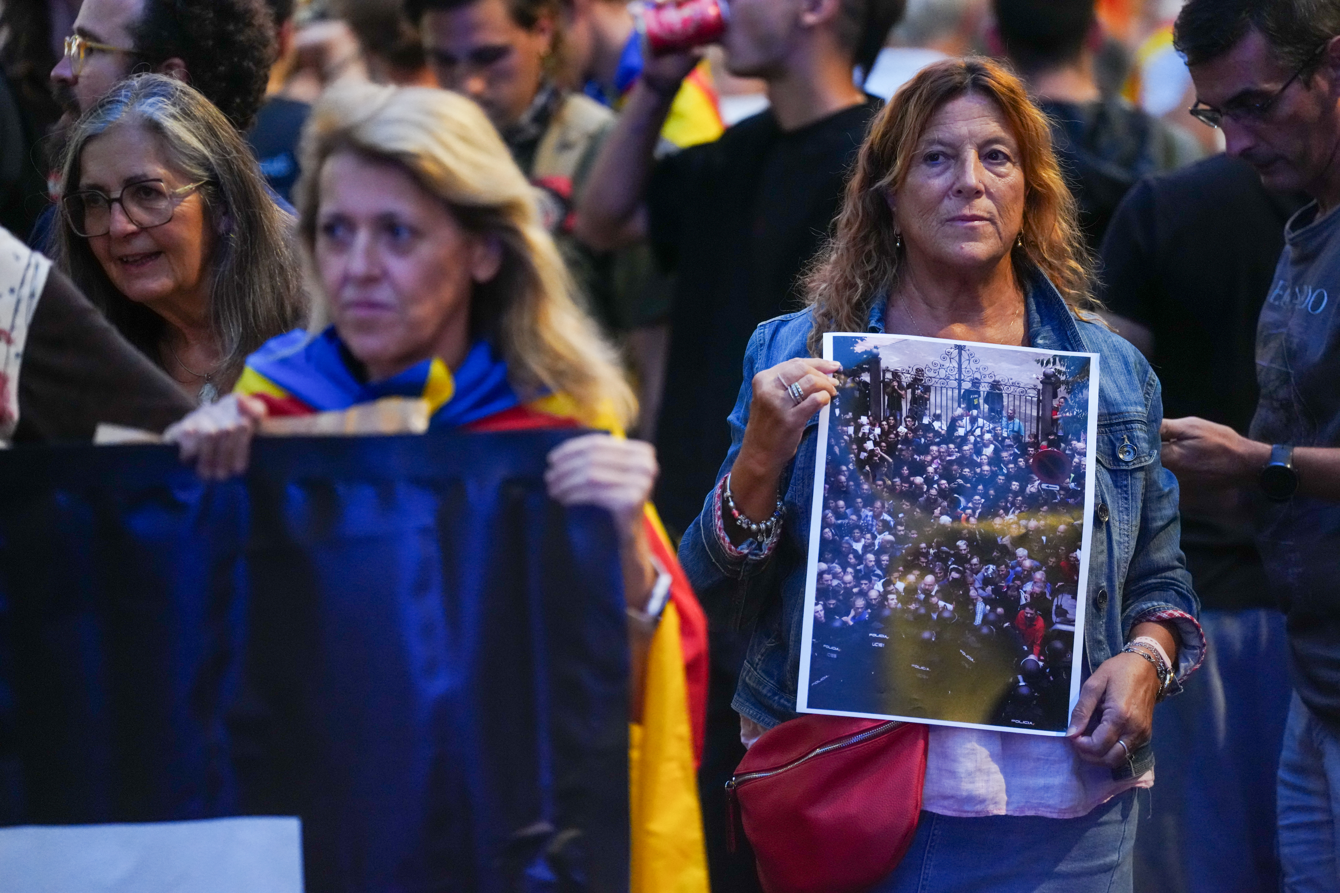 A woman holds up a photograph during a demonstration in Barcelona's Plaça Urquinaona marking the ninth anniversary of the October 1, 2017 independence referendum