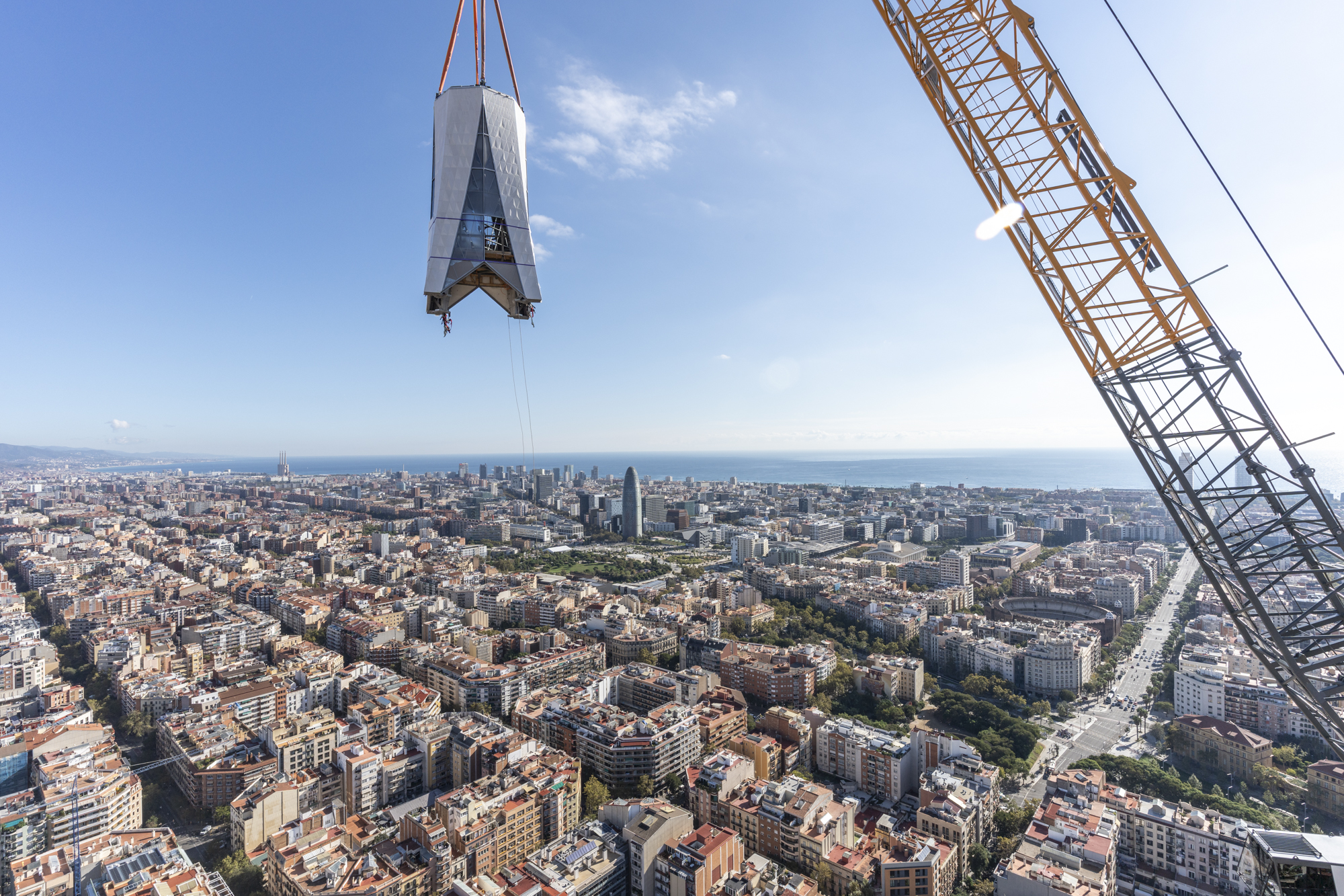 One of the parts of the cross of the Tower of Jesus Christ of the Sagrada Família flying over Barcelona